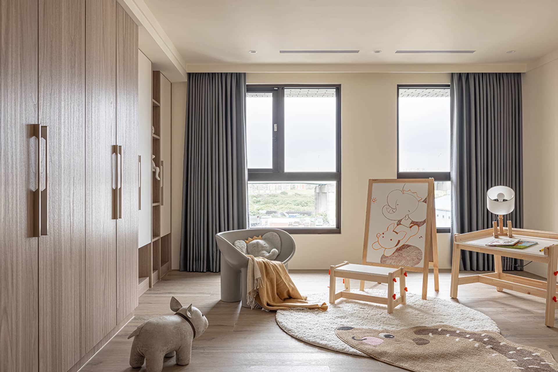 A modern children's room featuring wooden furniture and decor, with gray curtains and a large window providing natural light.