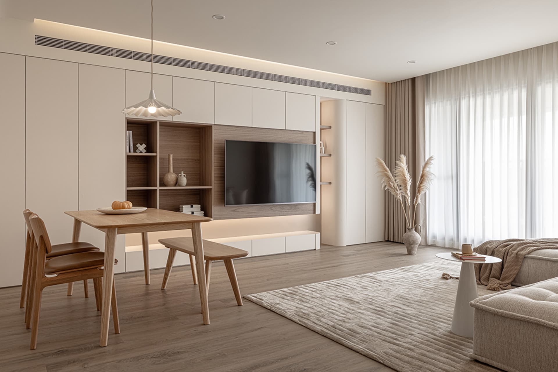 A modern living room with wooden furniture, leather accents, and glass elements, featuring a dining table, sofa, pendant ligh
