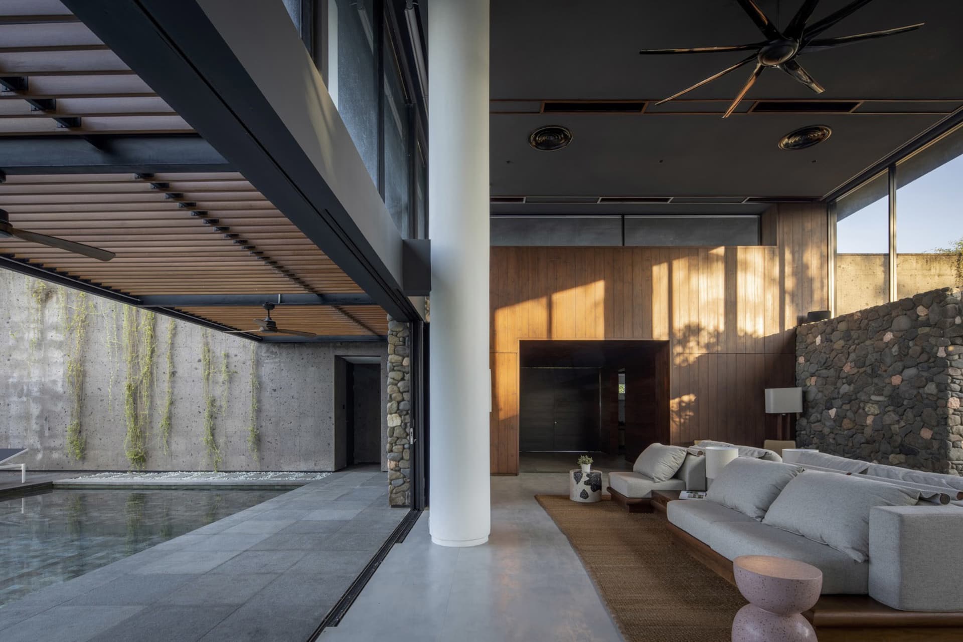 A modern residential living room featuring concrete and stone materials.