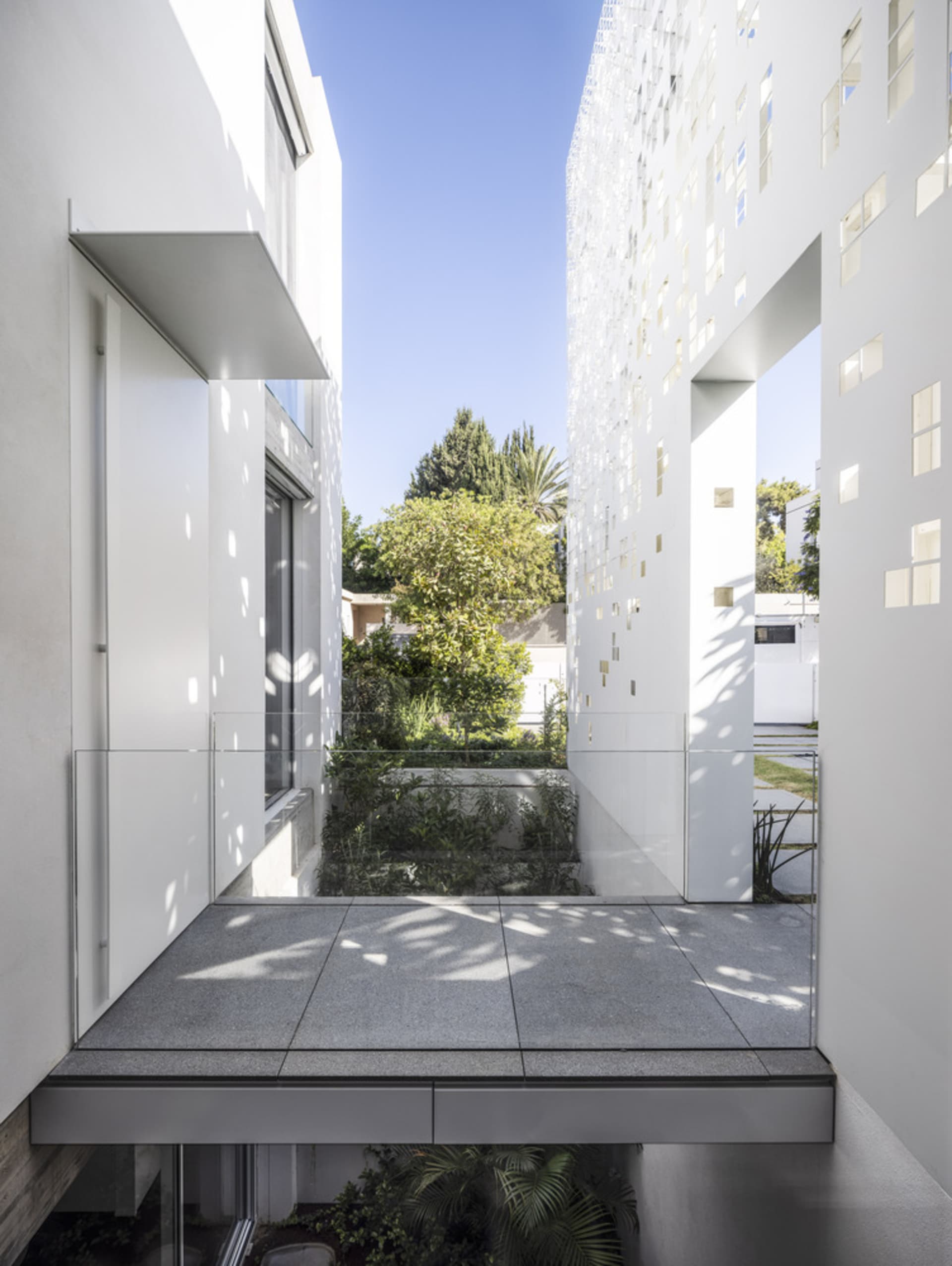 Modern architectural design featuring a glass exterior with tiled and concrete elements.