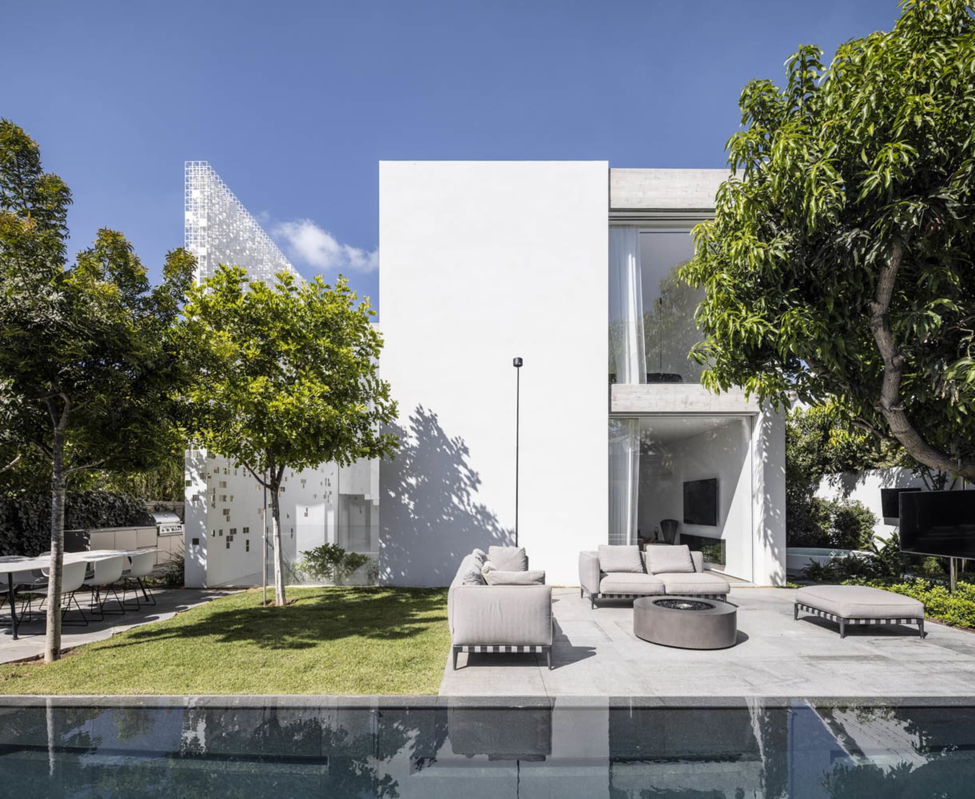 Modern house with a white concrete exterior and large glass windows.