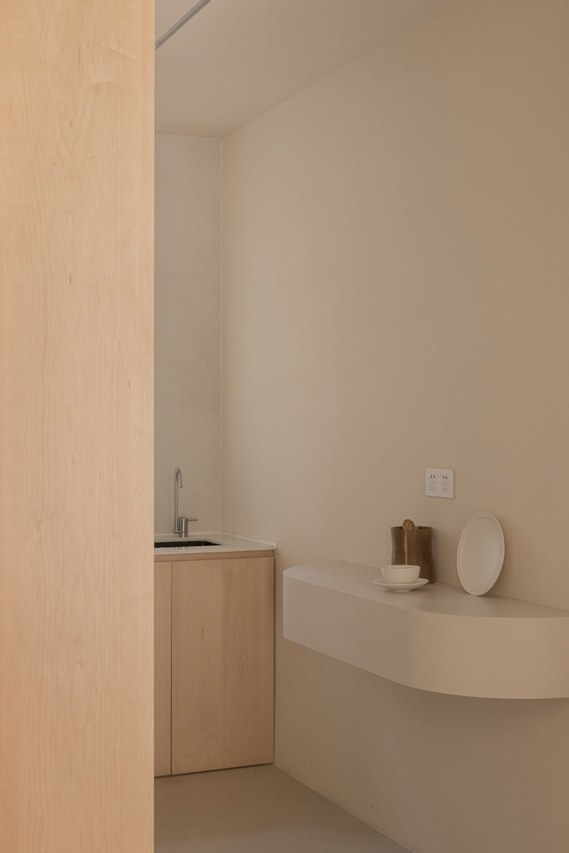 Modern minimalist kitchen with wooden cabinets and sleek lines.