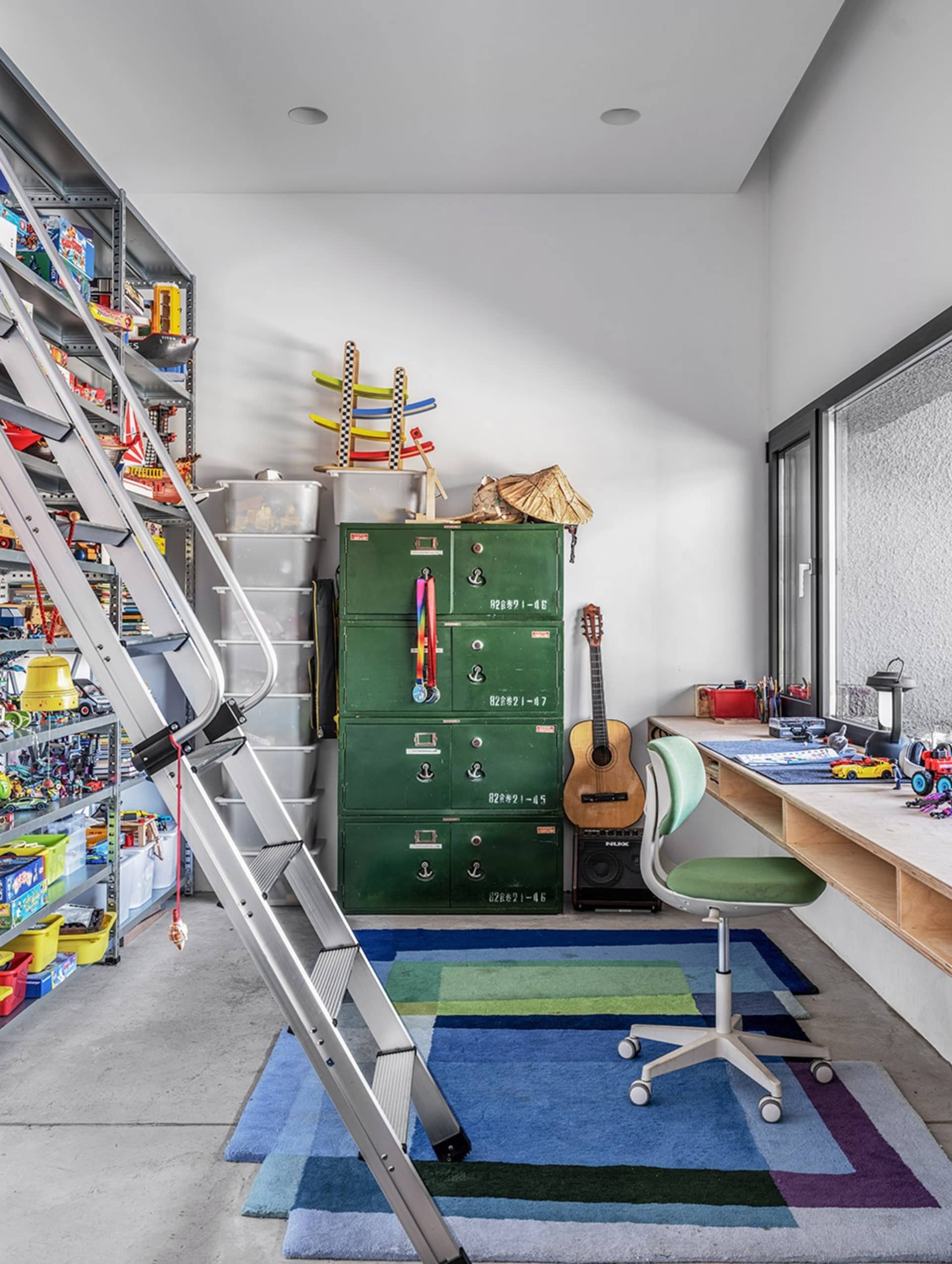 A garage with industrial-style metal cabinets, a concrete floor, and various toys and tools.