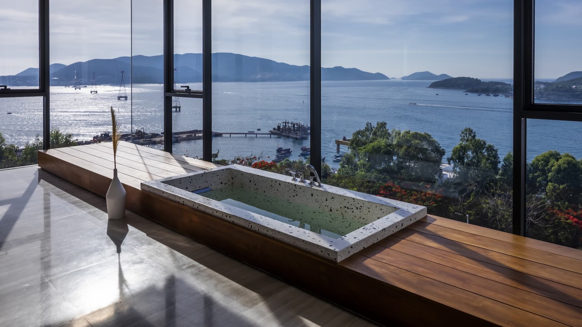 Modern bathroom featuring a concrete bathtub with a stunning view of the ocean.