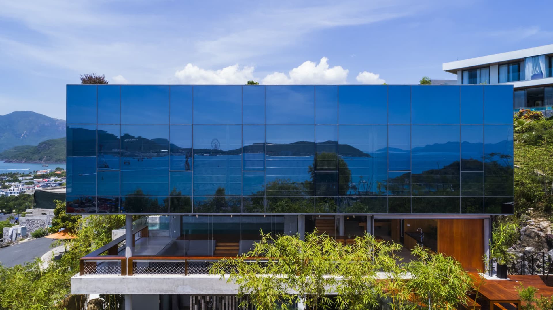 Modern building with glass facade reflecting surrounding scenery.