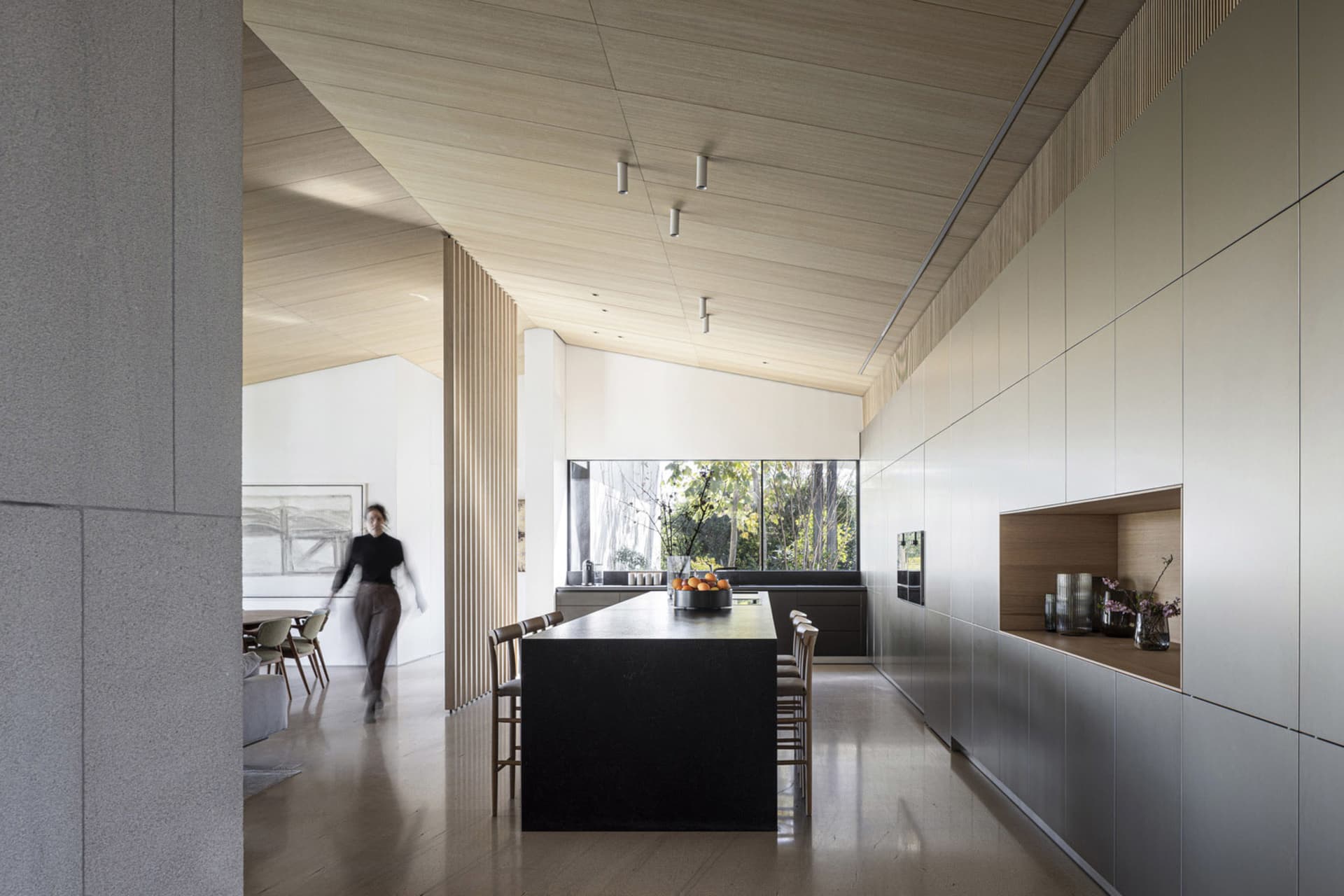 A modern residential kitchen featuring dark wood cabinets and a matte black kitchen island