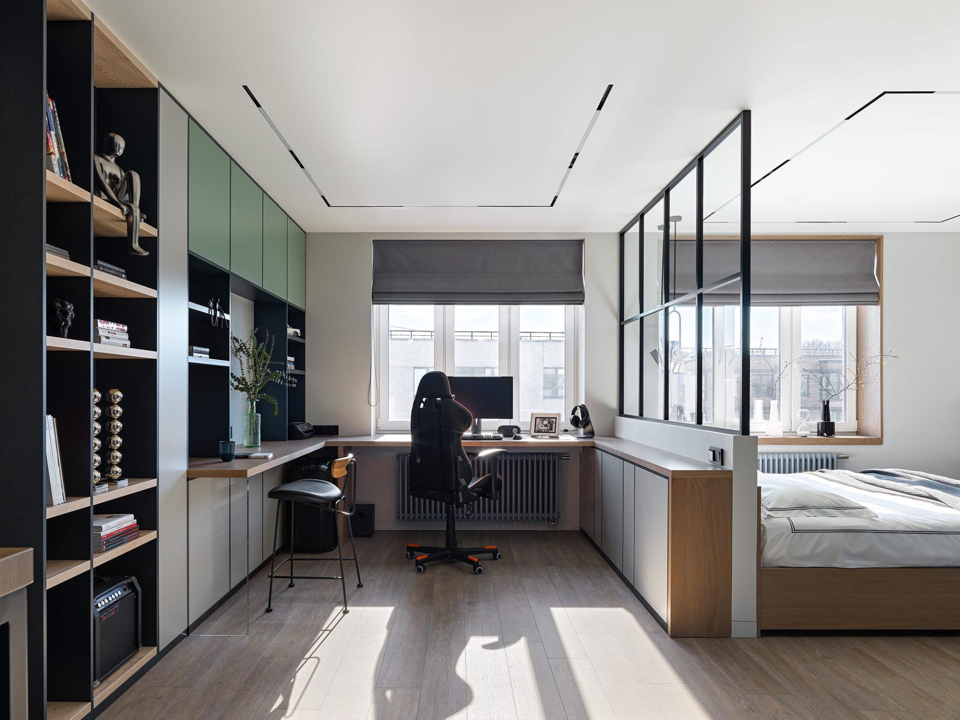 A modern bedroom featuring glass windows, a desk, and a bed.