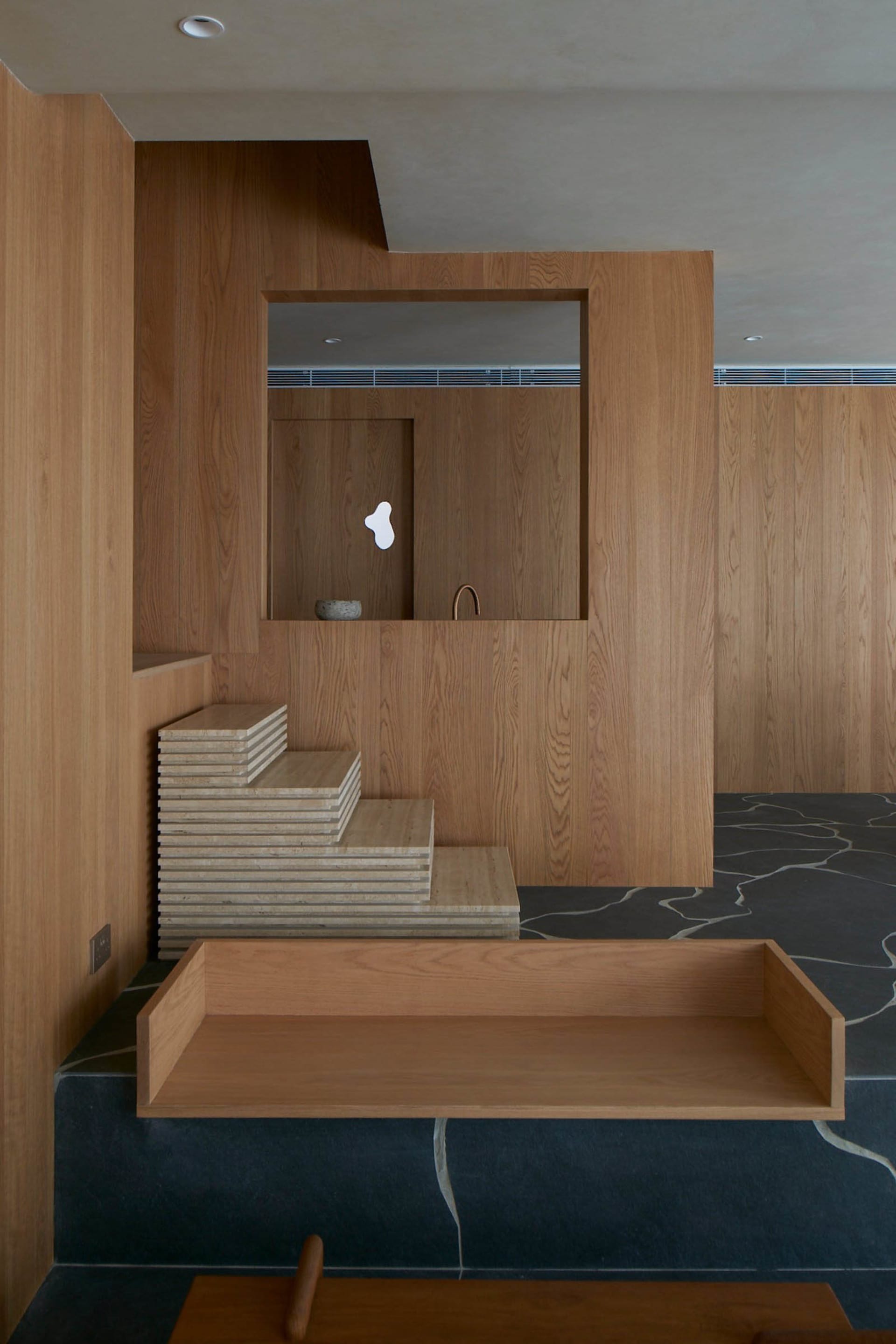 Modern, minimalist bathroom featuring concrete elements and textured, wooden accents.