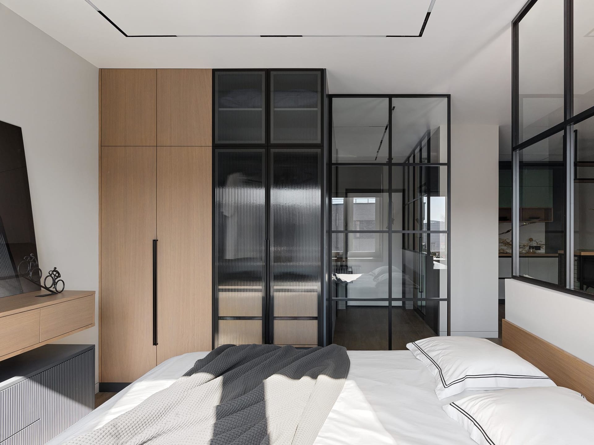 Modern minimalist bedroom featuring a wooden bed and glass closet doors