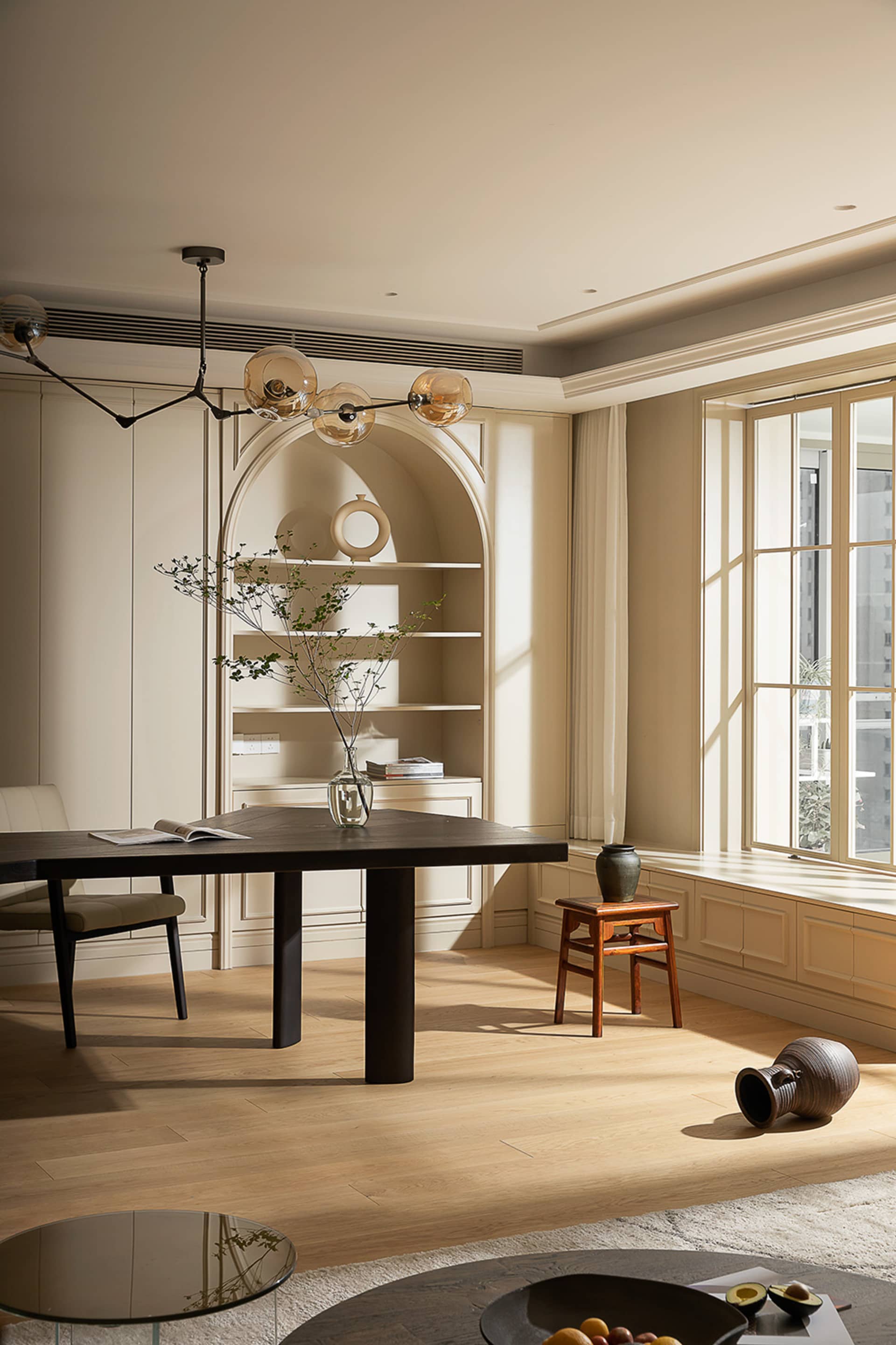 A modern residential dining room featuring a dark wooden table and natural wood finishes.