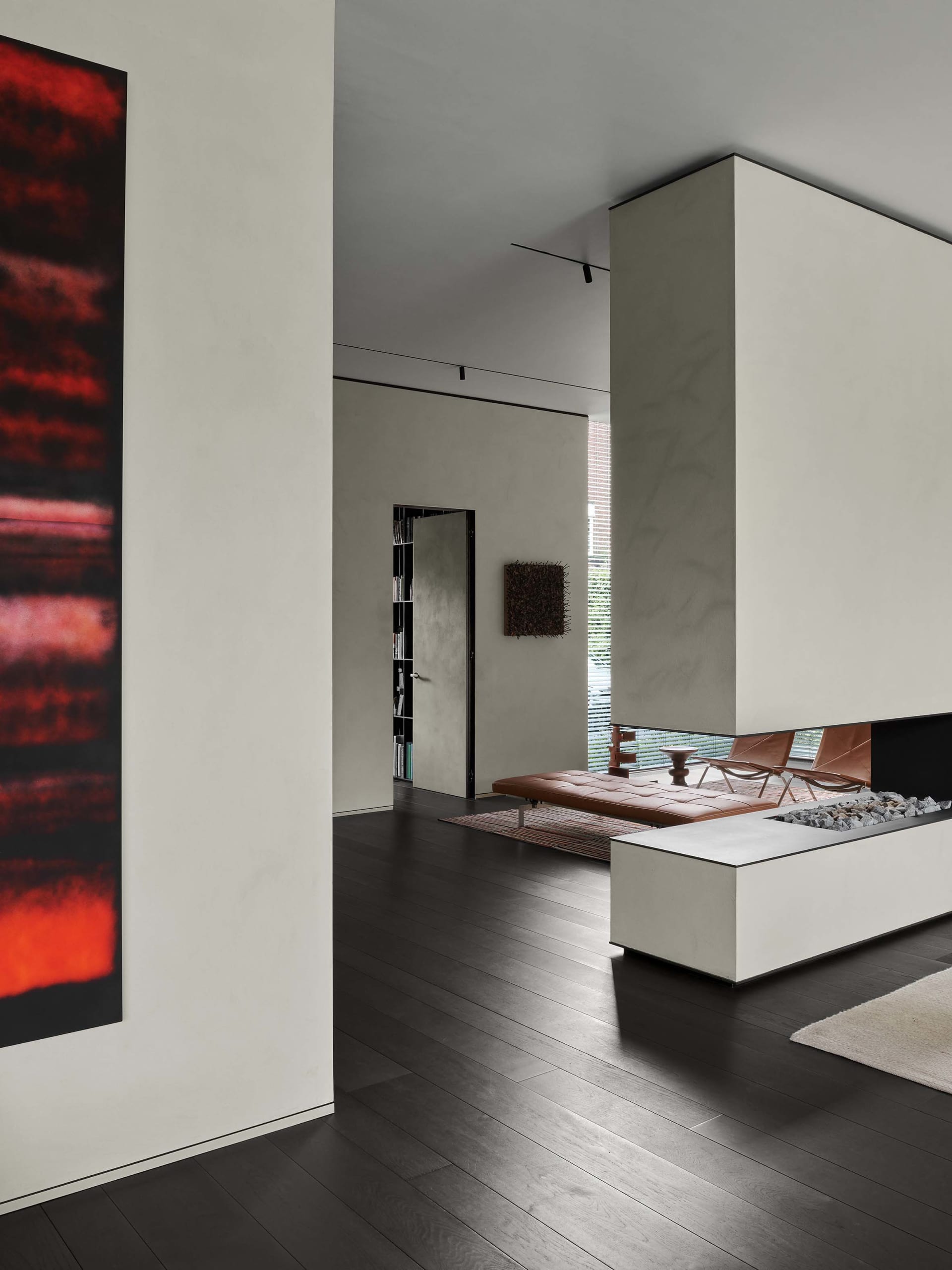 Minimalist living room with concrete fireplace and dark wood flooring