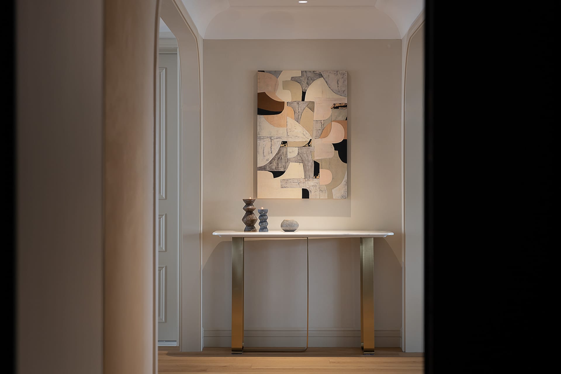 A minimalist entryway with a modern console table featuring sleek, geometric shapes and a neutral color palette.