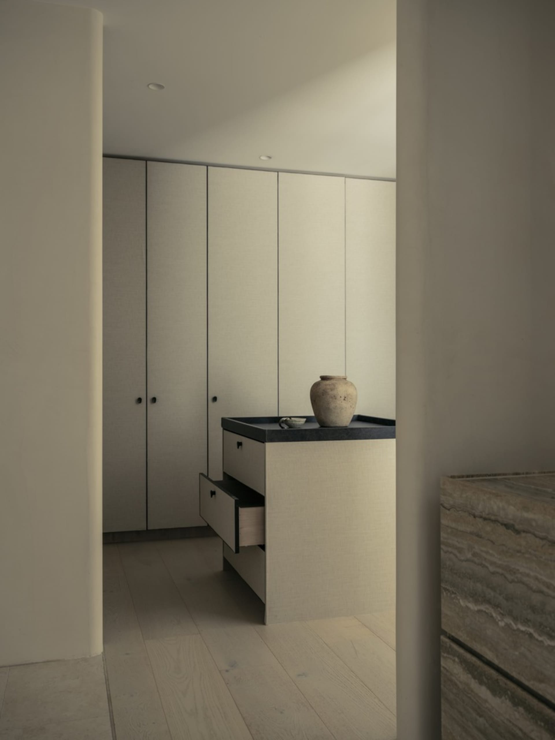 A modern minimalist kitchen with a laminated wood countertop and cupboard.
