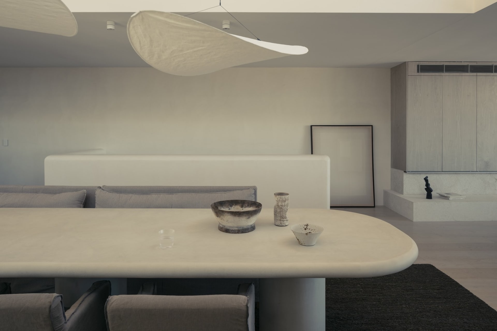 A modern living room with concrete furniture and minimalist design.