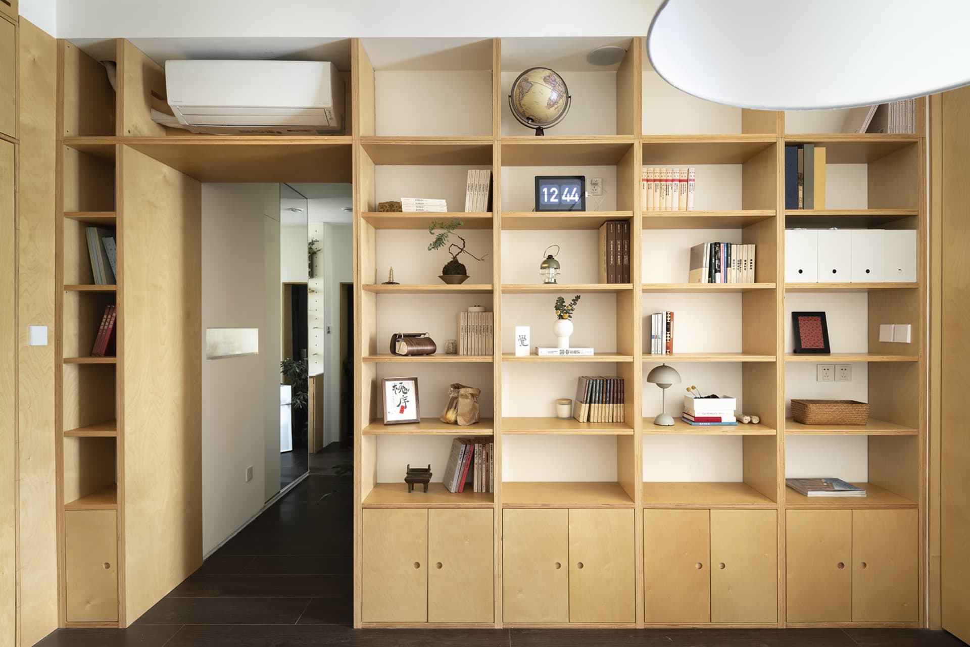 A well-designed modern living room with wooden bookshelves filled with books and decorative items.