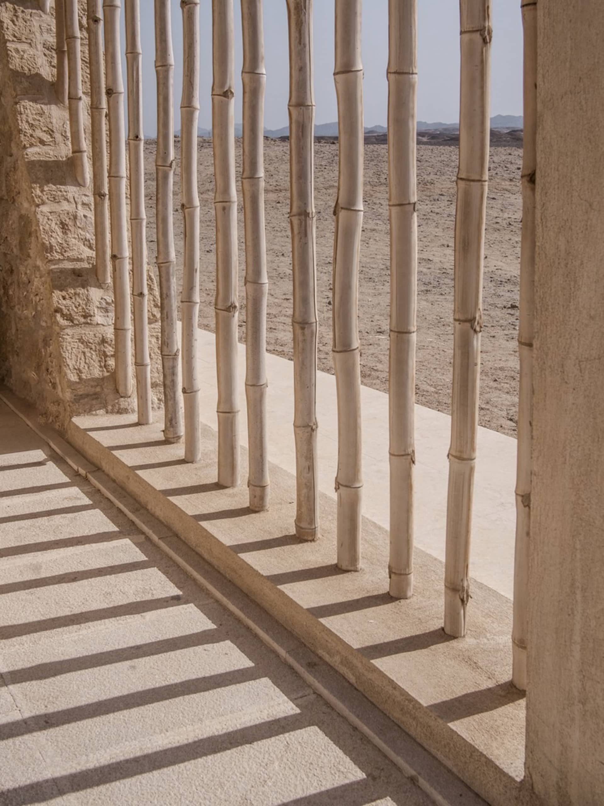 Concrete columns of a porch overlooking a desert view.