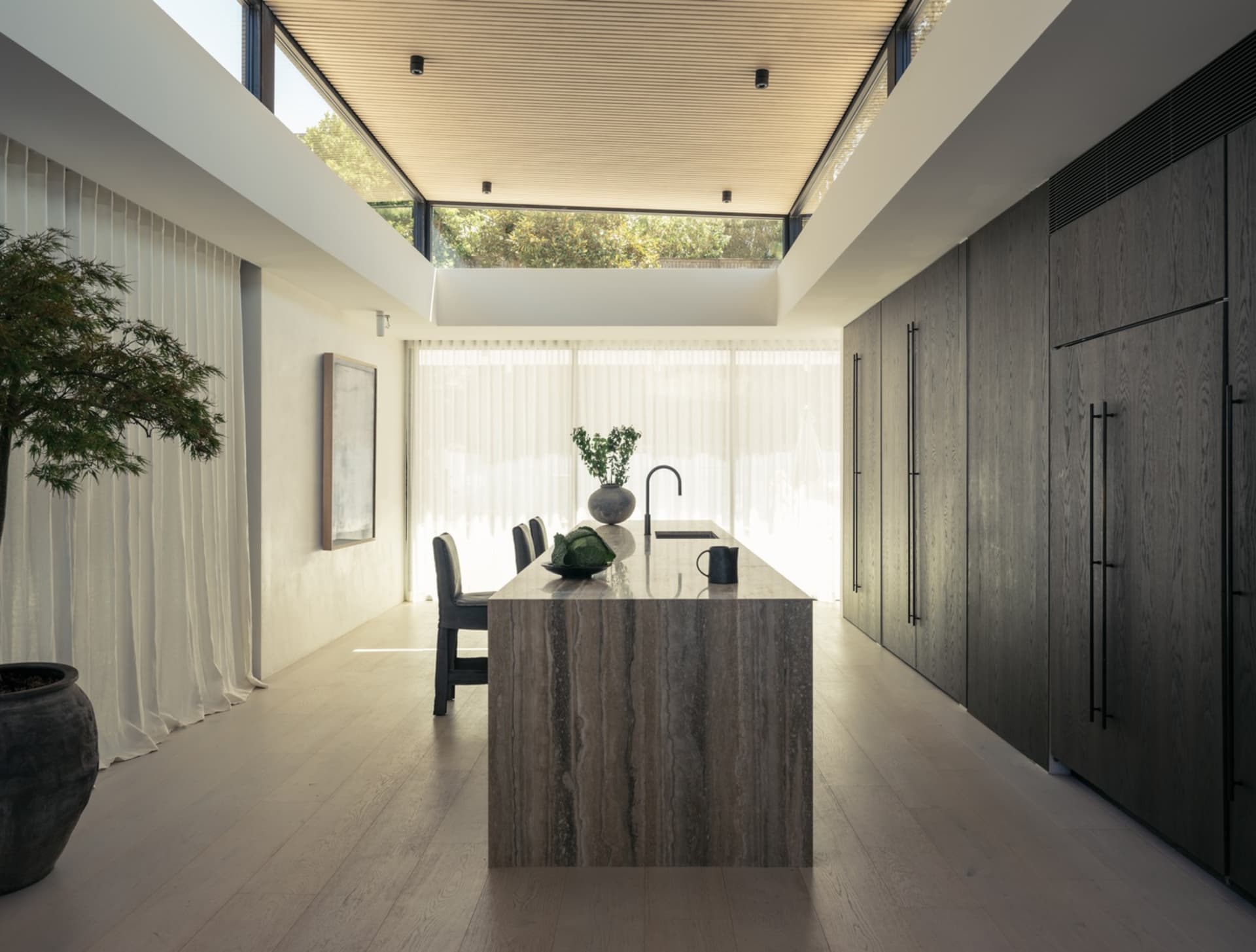A modern, contemporary kitchen featuring elegant marble laminate countertops, sleek cabinets, and a large island.