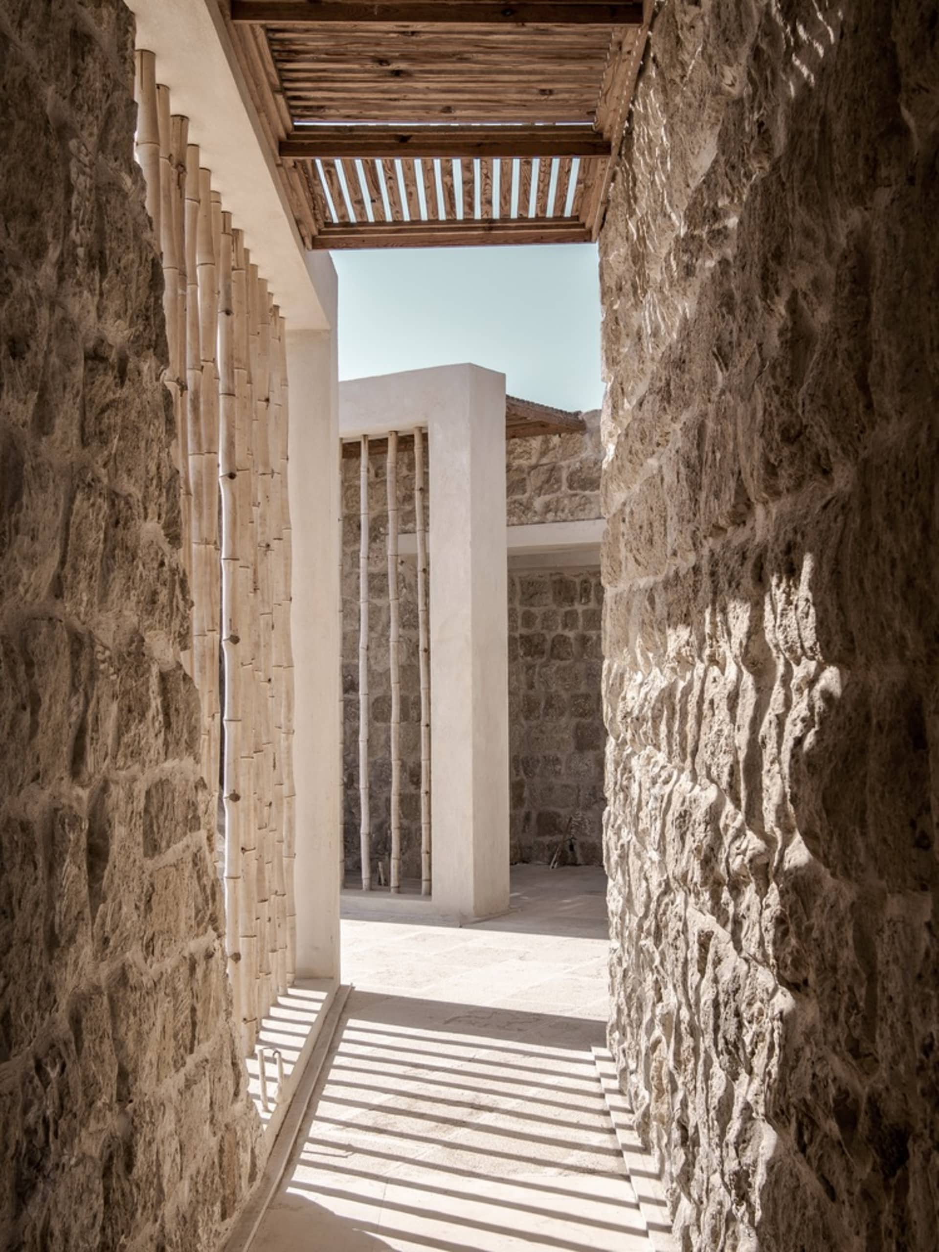 A modern interior space featuring stone columns and a stone wall.