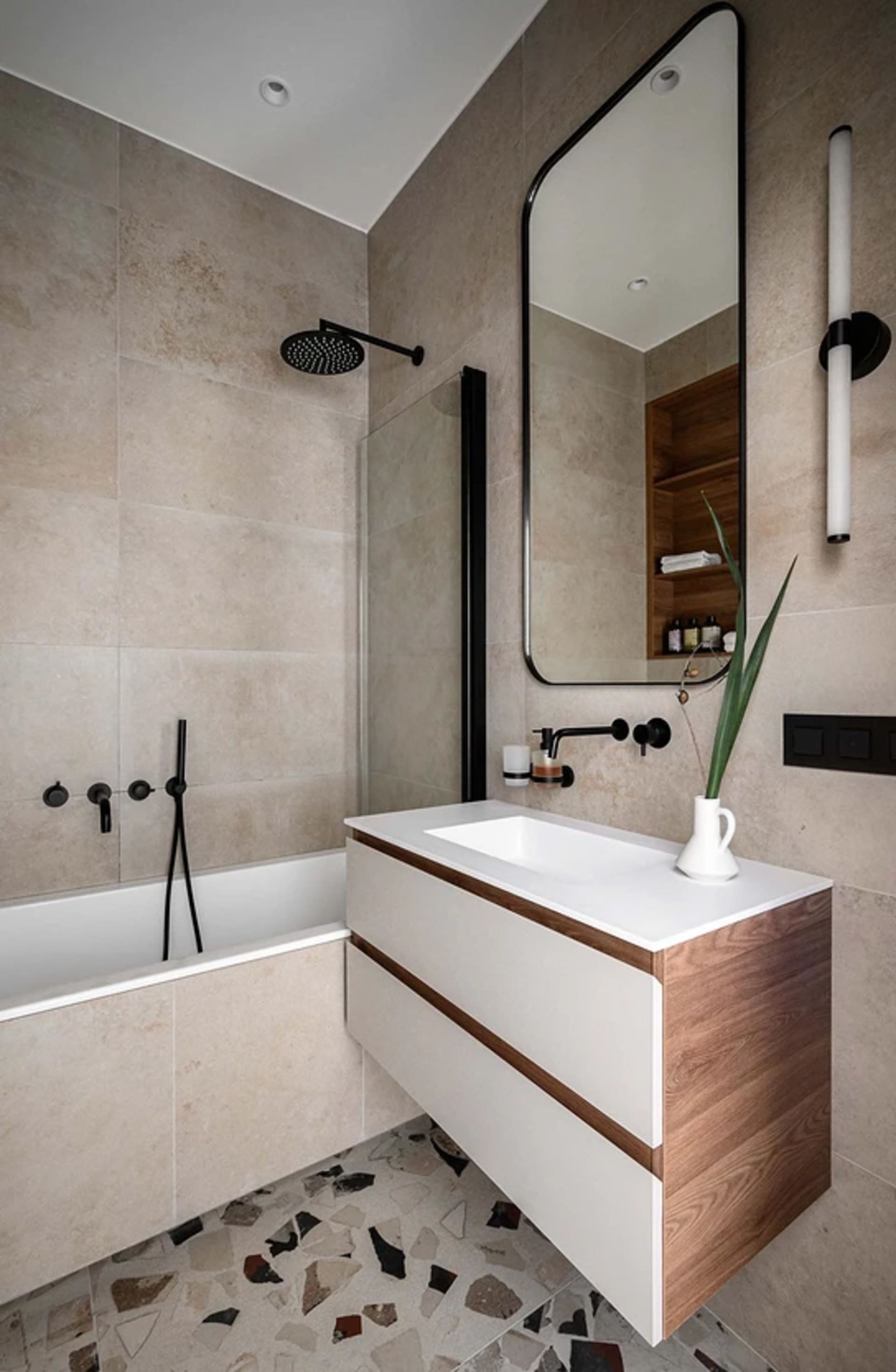 Modern bathroom with white fixtures, terrazzo tile flooring, and a floating vanity with a white countertop.