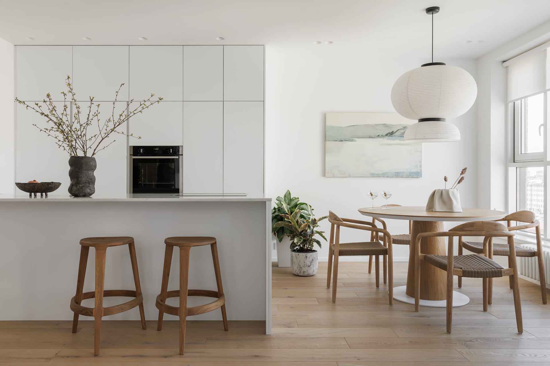 Modern dining room featuring white marble surfaces and wooden furniture.