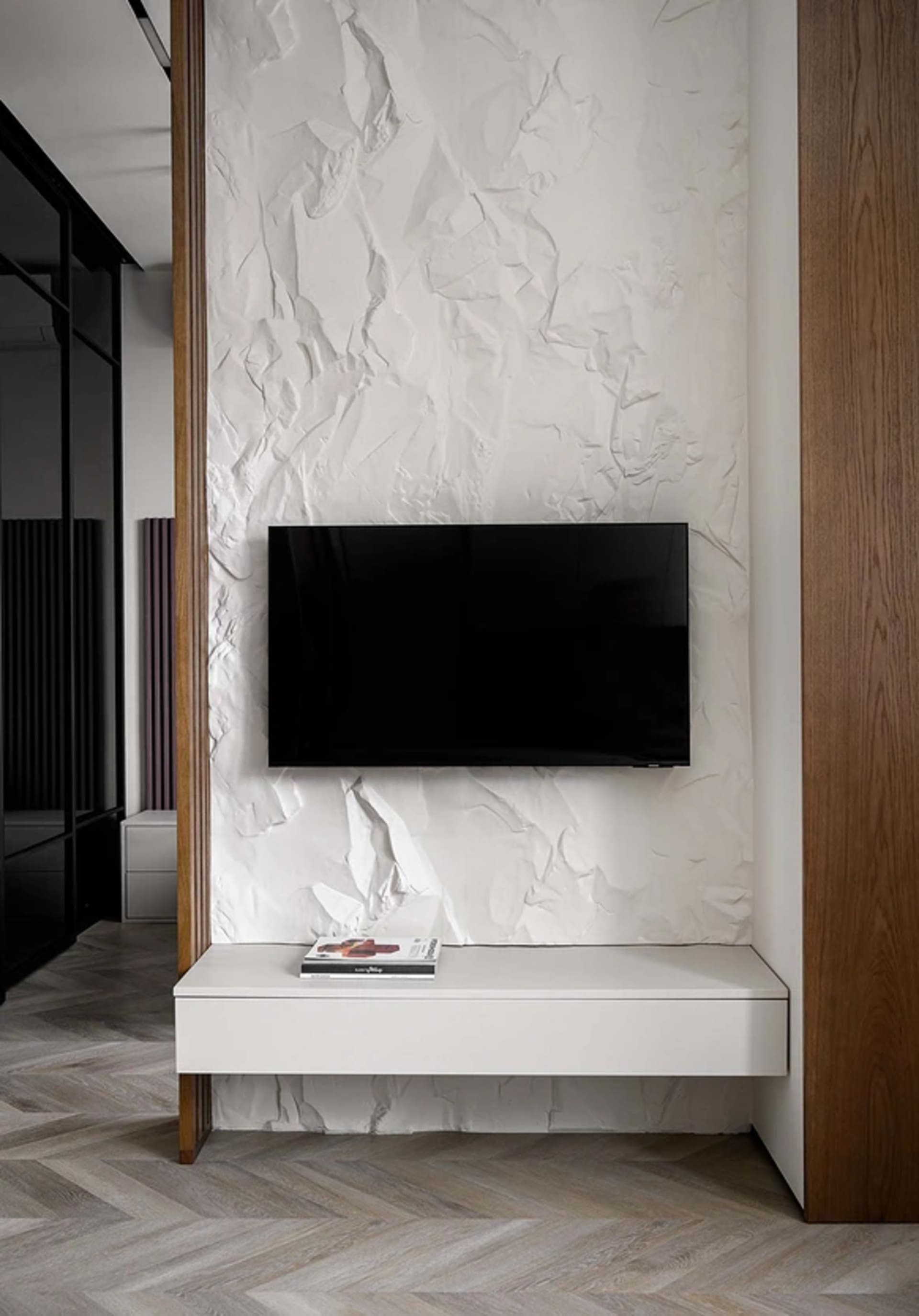 A minimalist living room with textured paper walls and a floating TV stand.