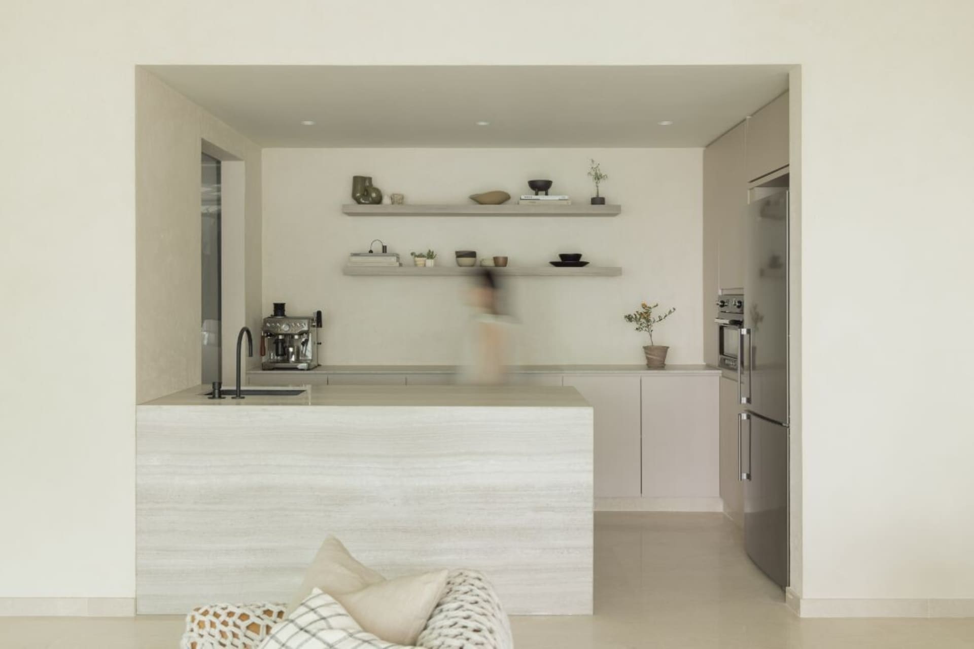 Modern, minimalist kitchen with concrete countertops and shelves.