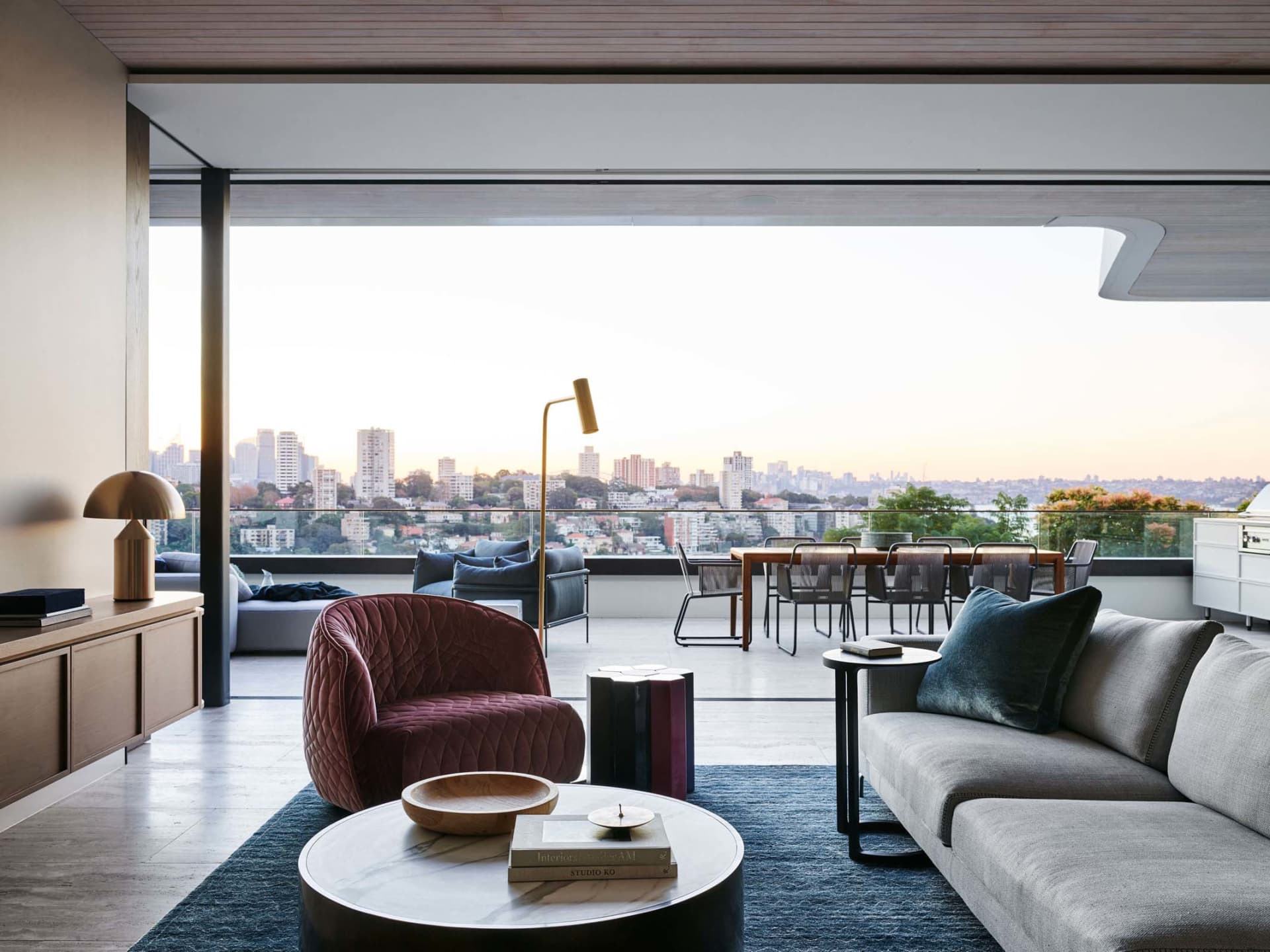 Modern living room with city view, featuring comfortable seating and a stylish coffee table.