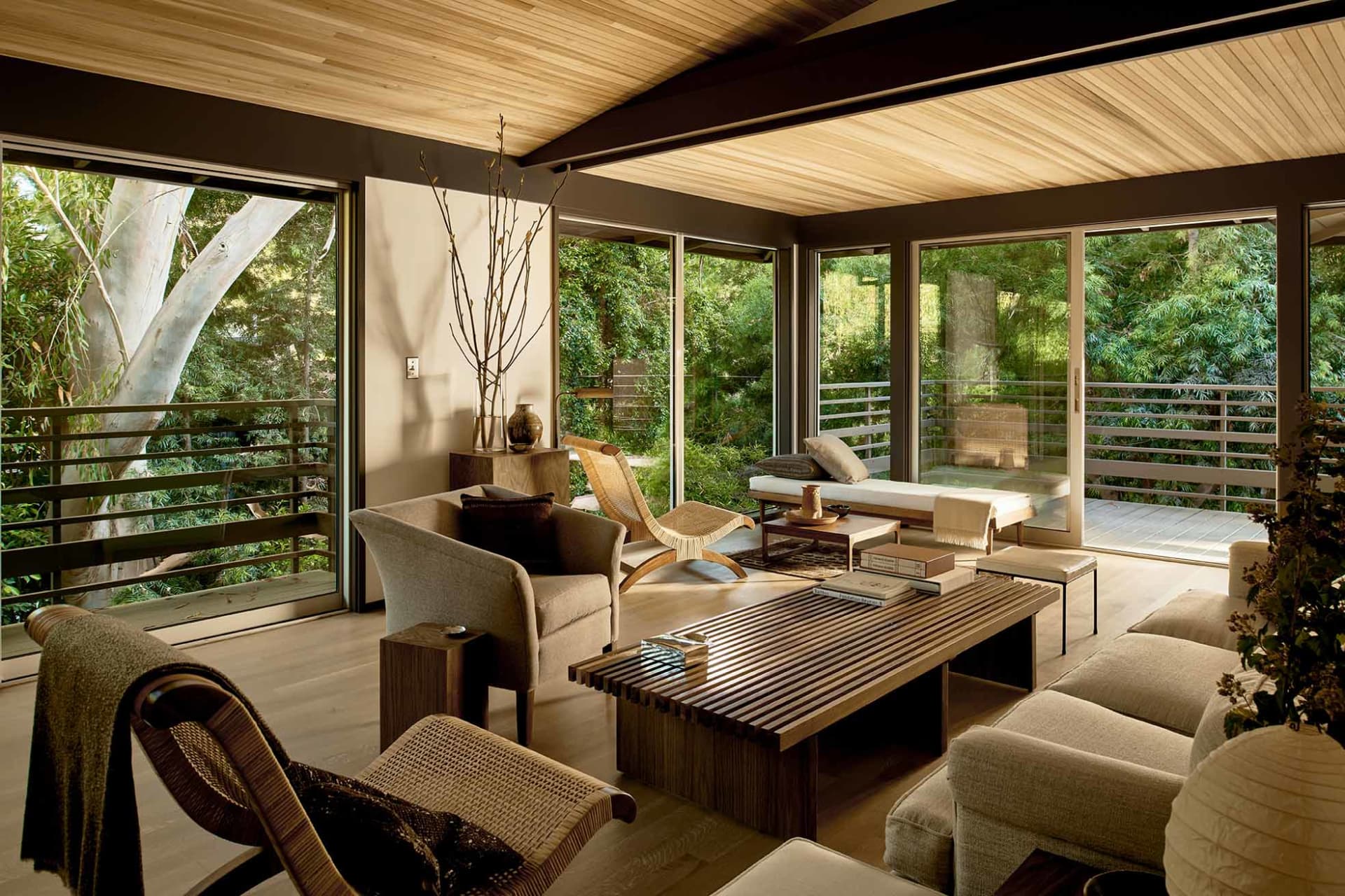 A contemporary living room featuring wooden furniture and a high wooden ceiling.