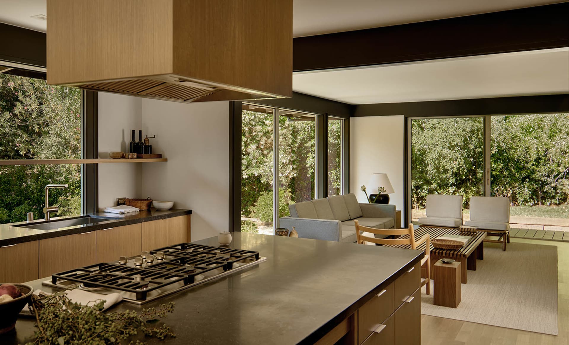 Modern residential kitchen with a wooden and oval-trafalged design featuring a central island with a stove, open shelving, an
