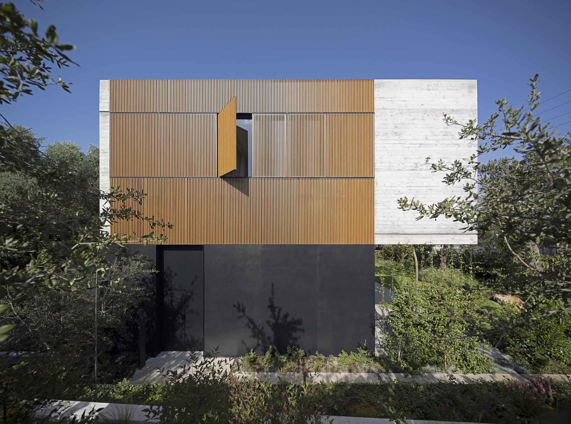 Modern residential exterior featuring a combination of wood and concrete materials.