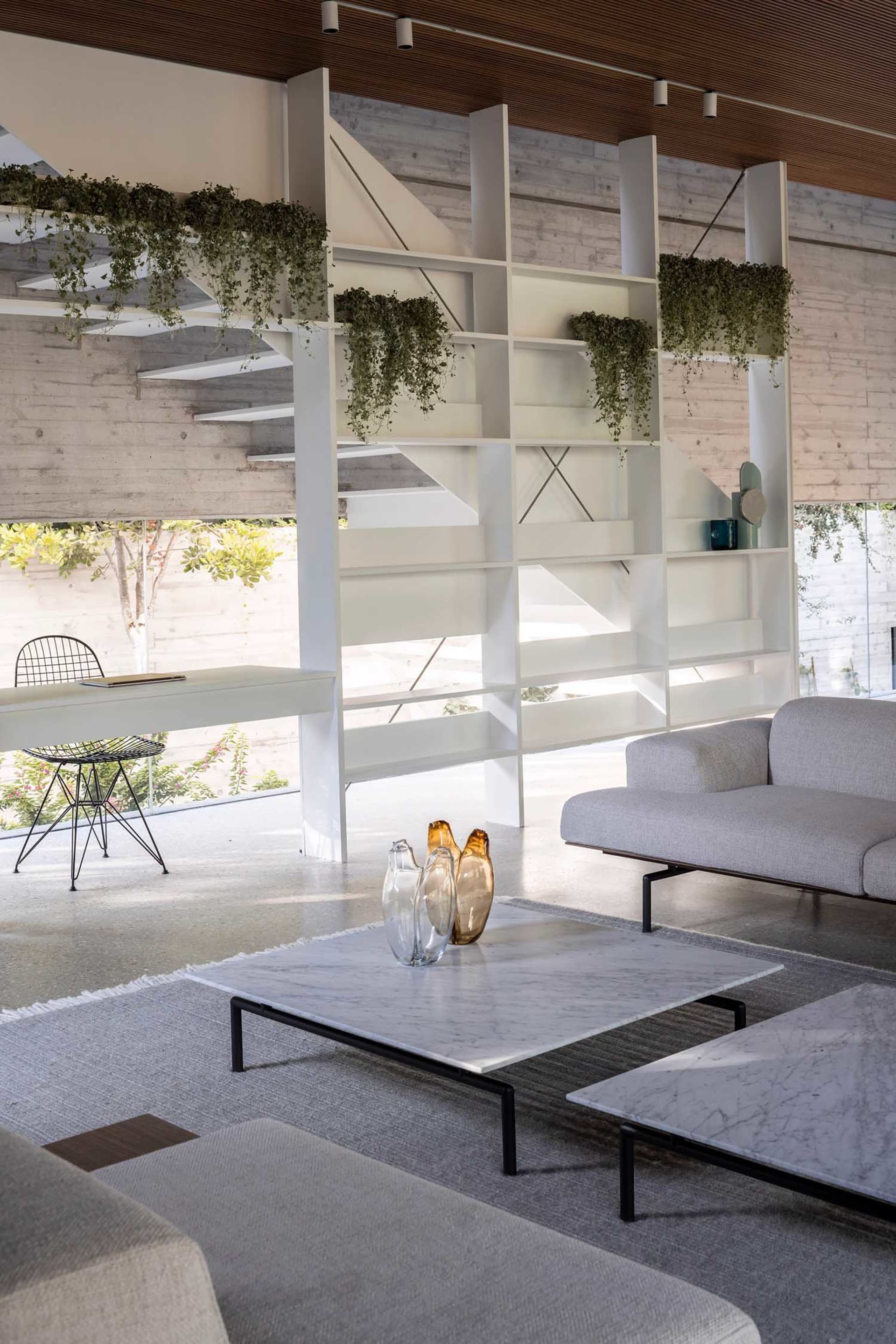 Minimalist living room featuring concrete walls and glass furniture.