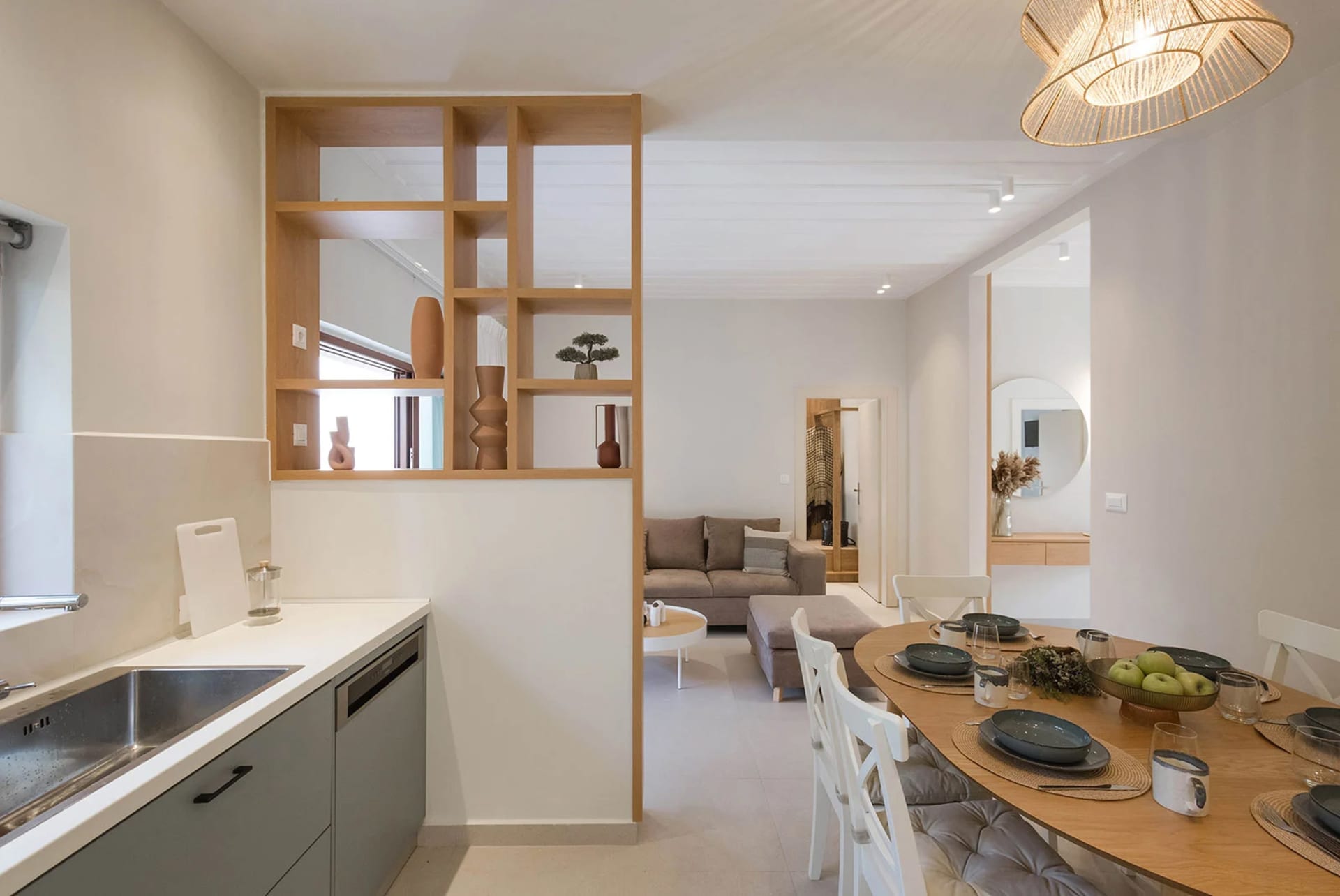 Modern minimalist kitchen dining and living room featuring wooden materials and furniture.