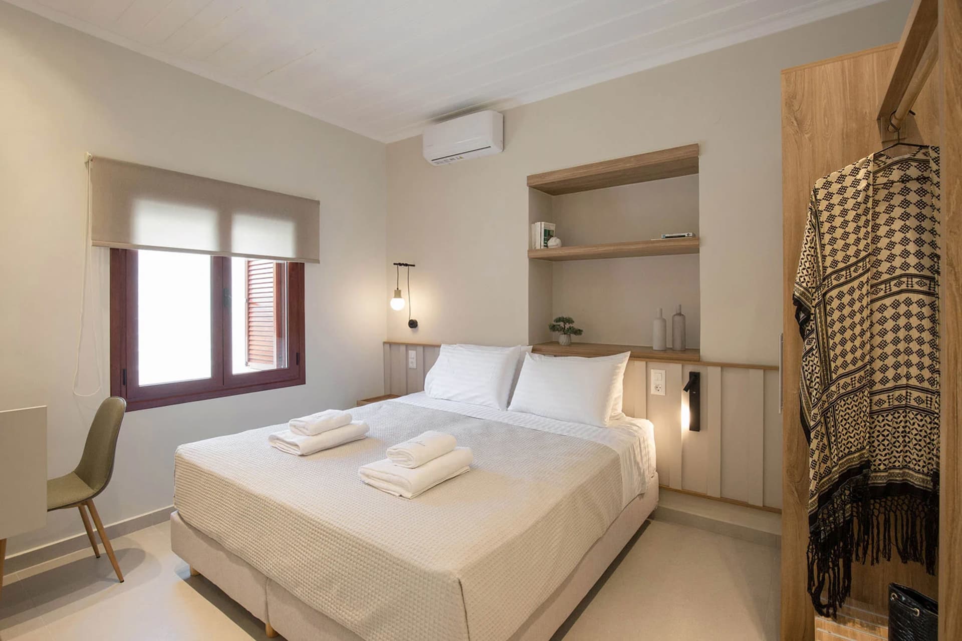 A minimalist bedroom featuring textured walls and a comfortable bed.