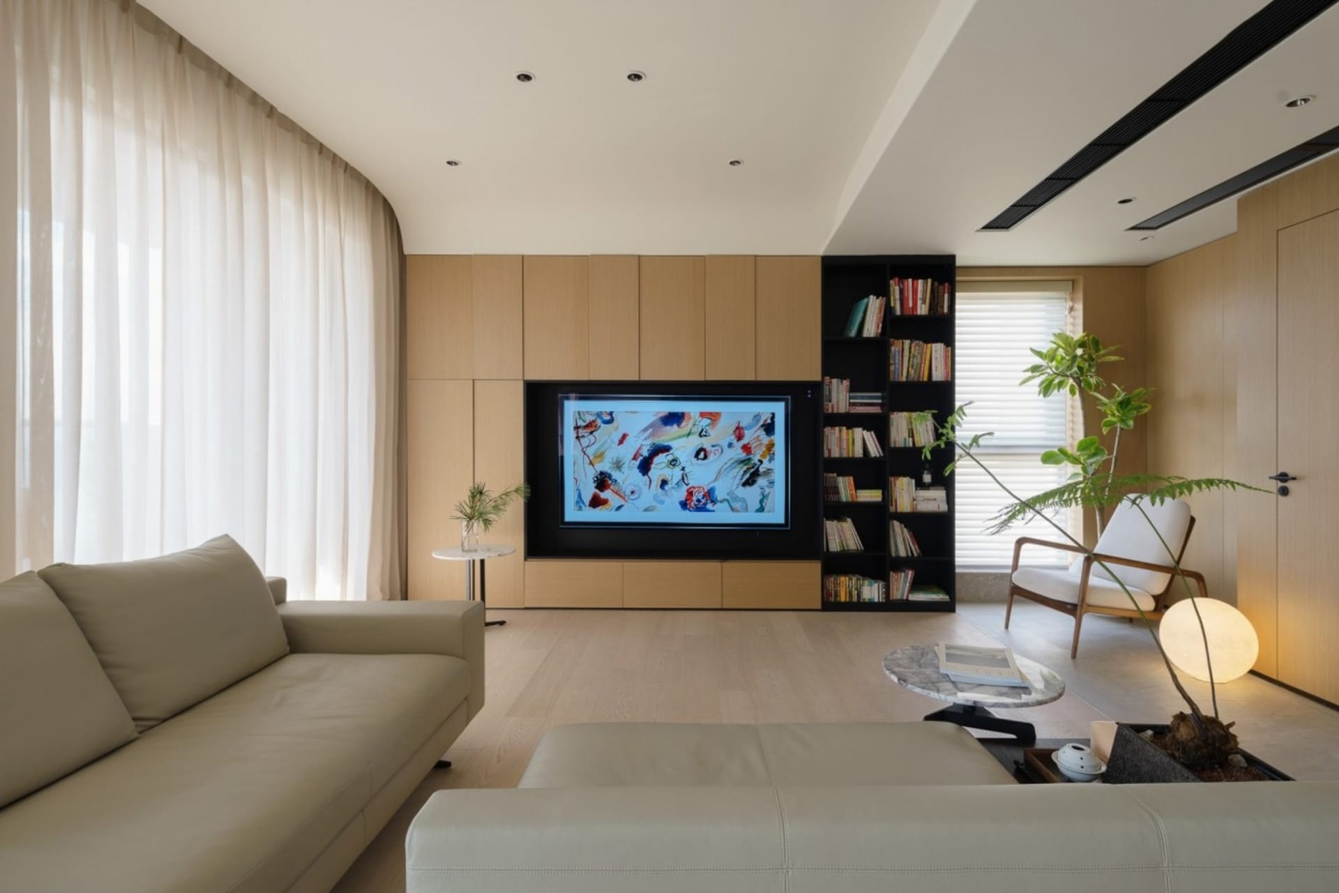 A modern minimalist living room featuring wooden furniture and a television displaying an abstract artwork.