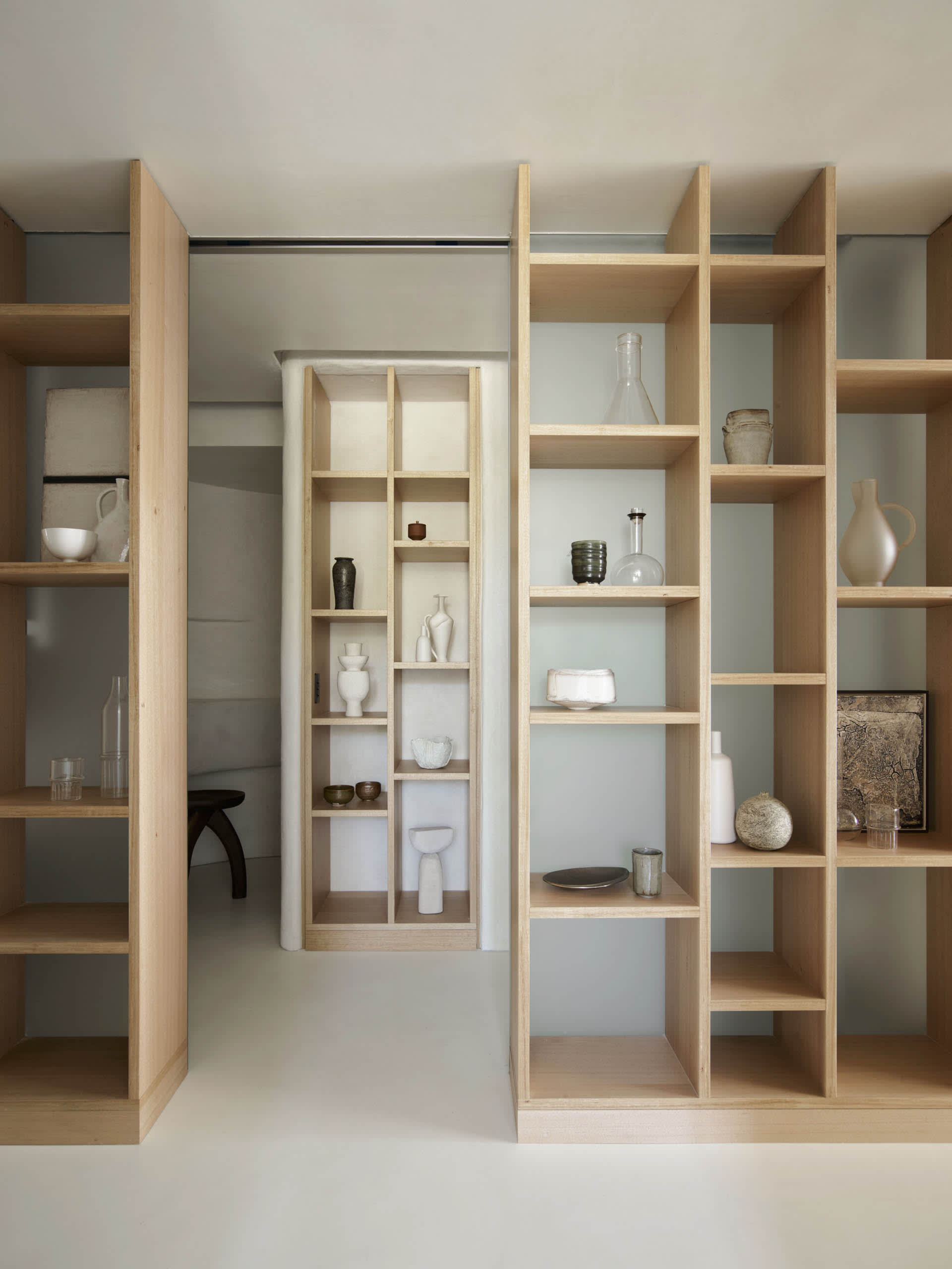 Modern interior design featuring wooden shelves with various decorative items.