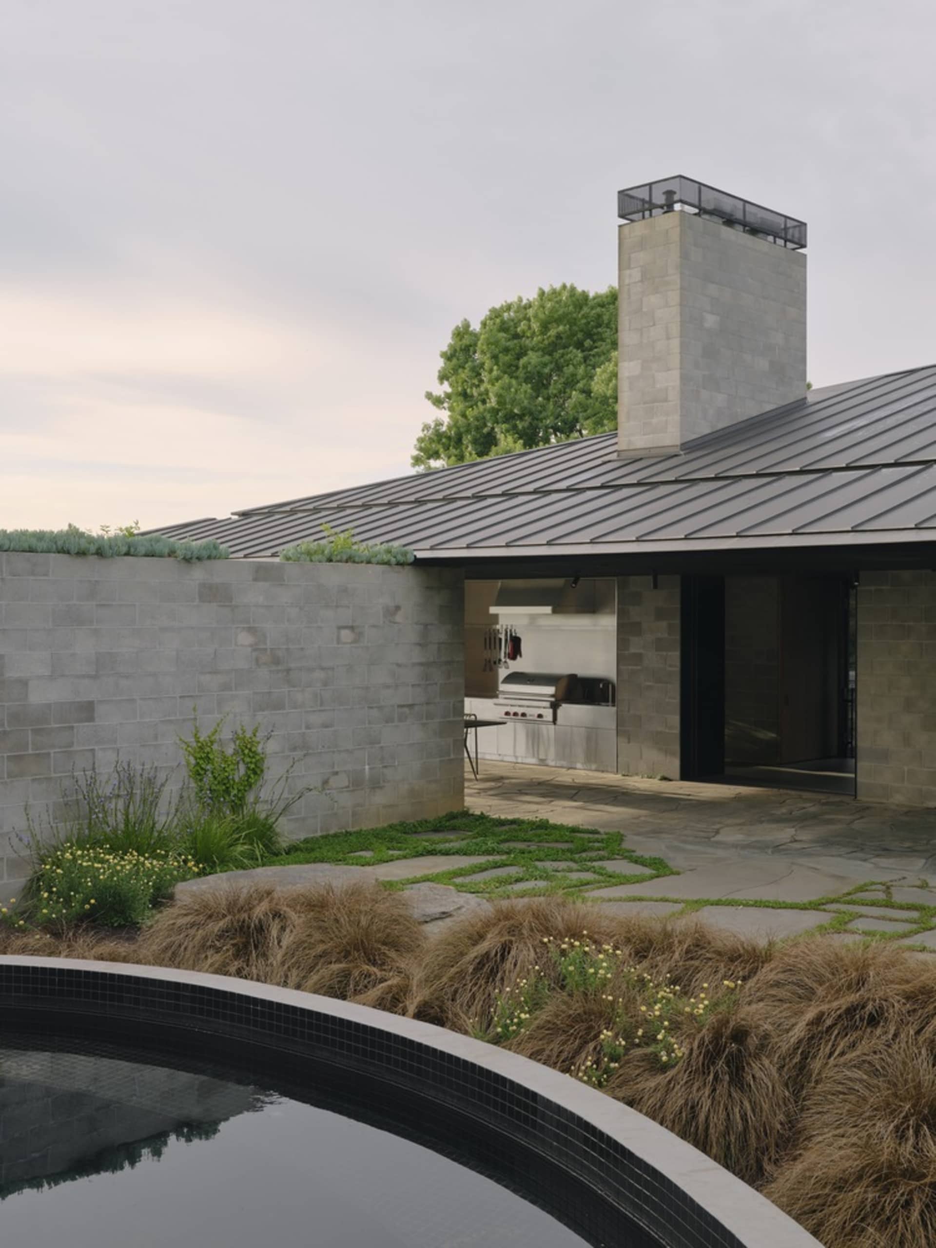 A modern residential exterior featuring concrete and metal materials with a glass window.