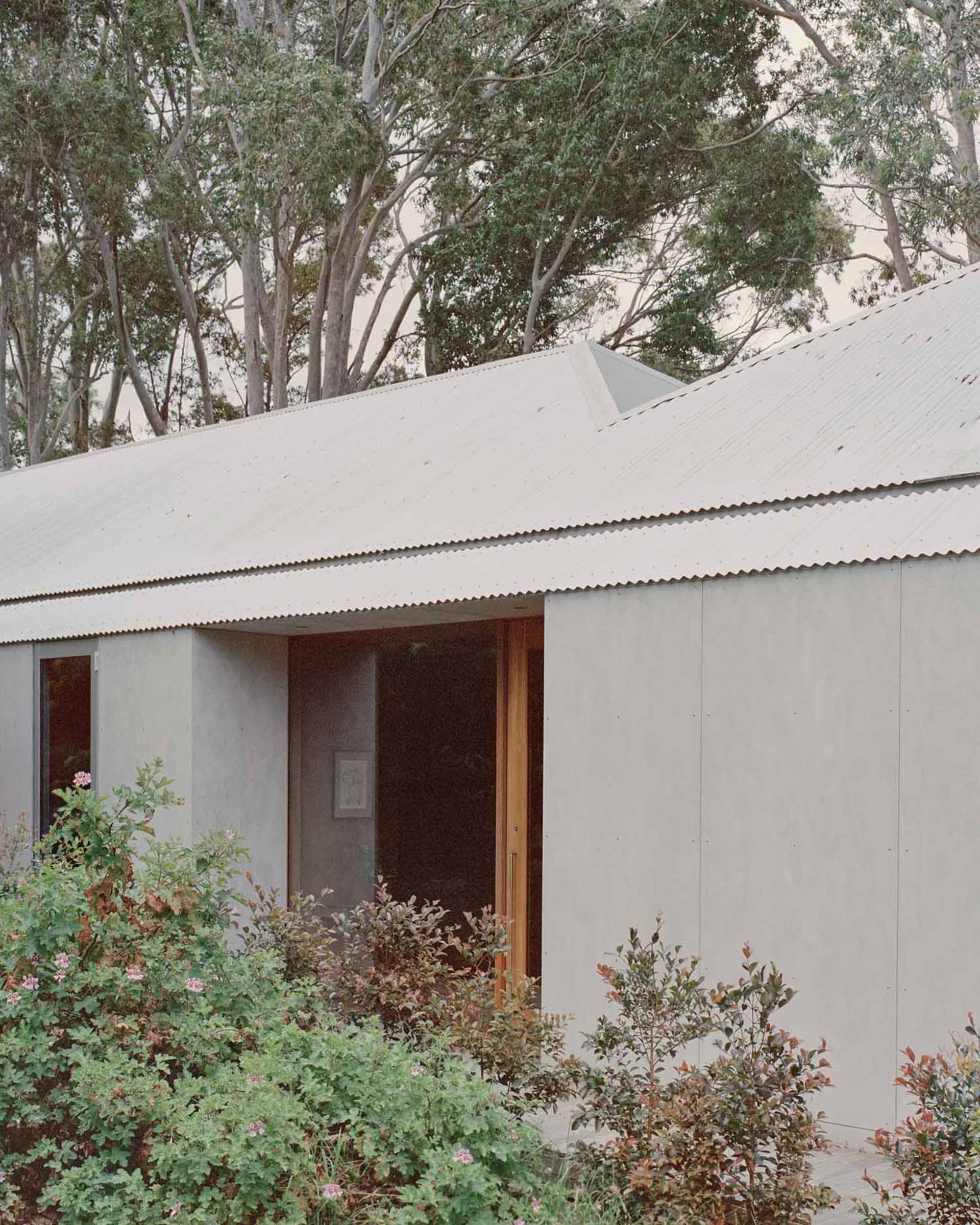Modern residential building with a white, corrugated metal exterior.