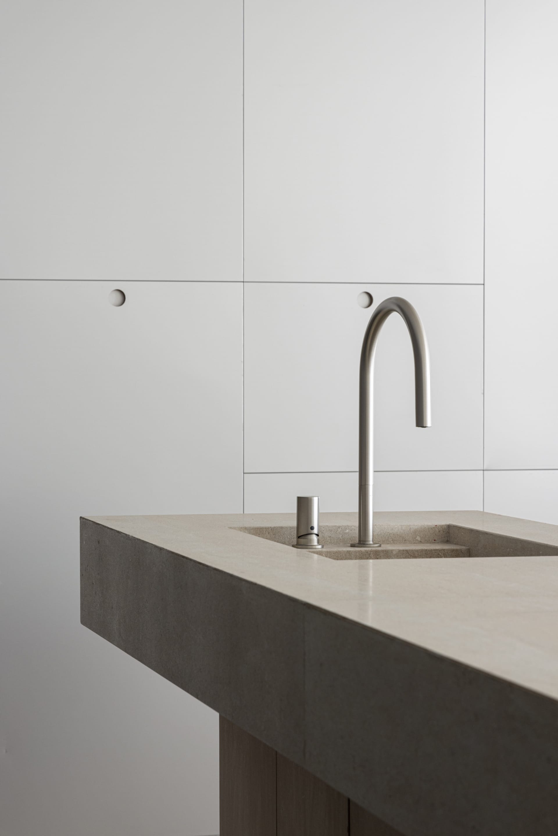 Modern bathroom featuring a concrete vessel sink and sleek faucet.