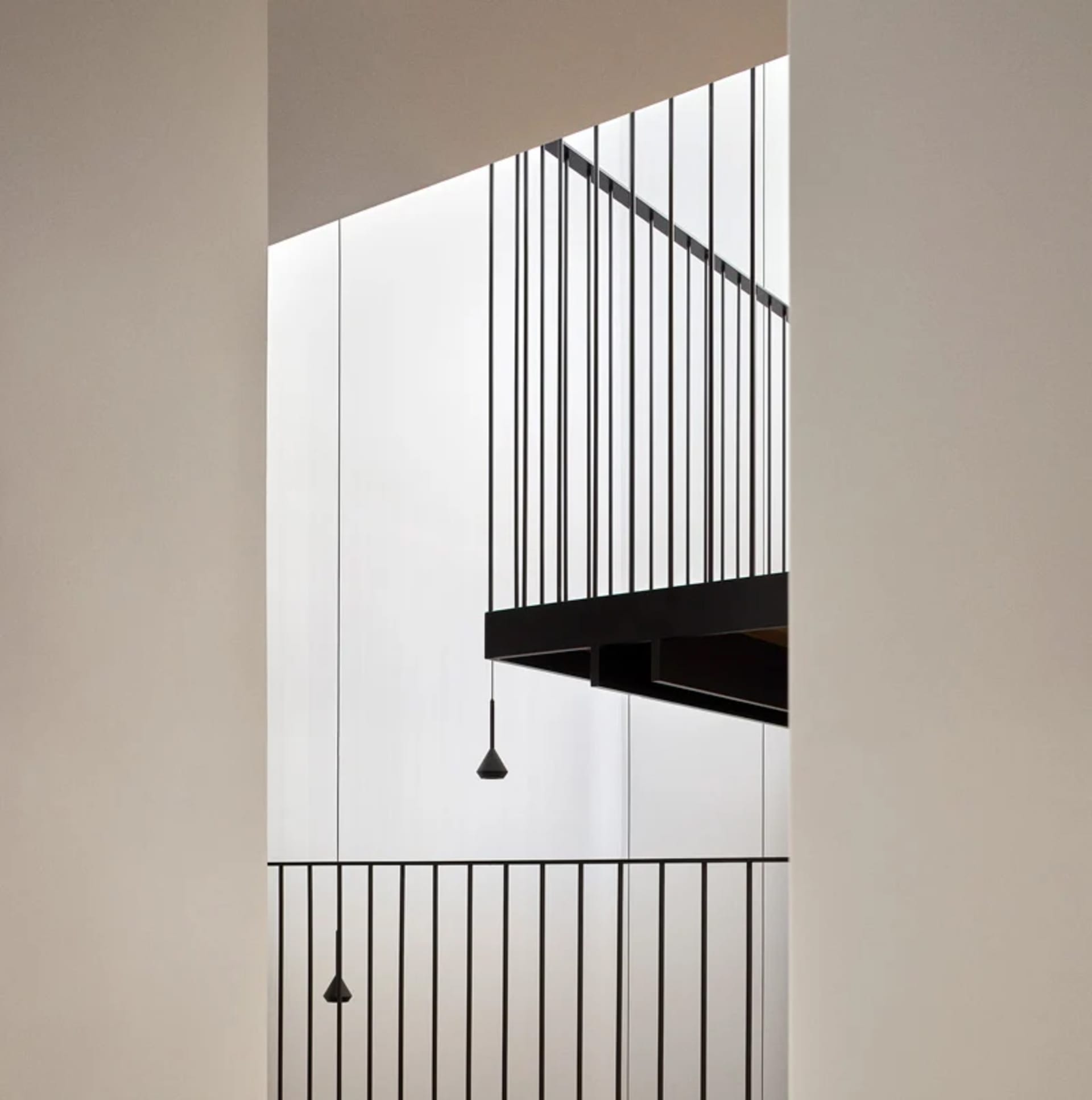 Modern, minimalist interior space with black metal railings.