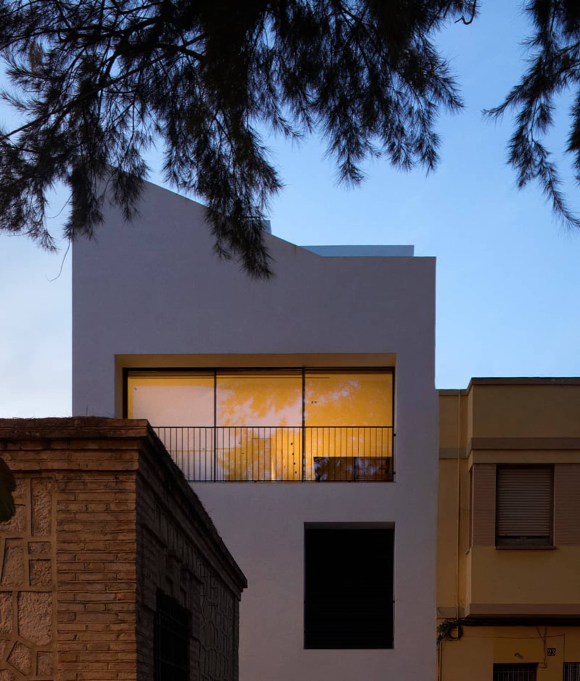 Modern, white, concrete residential building exterior at night