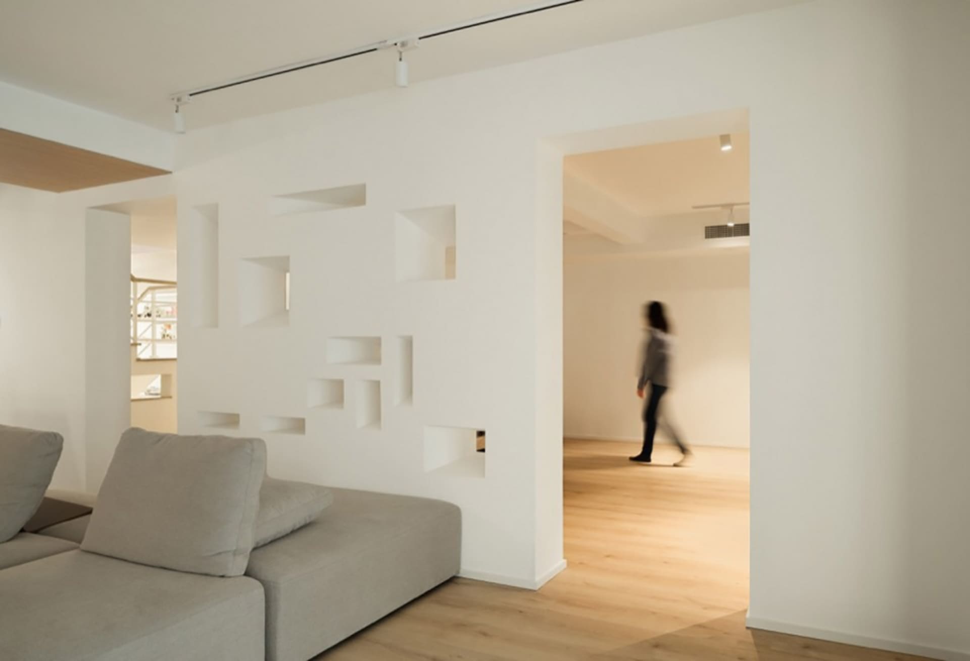 A minimalist living room with wooden furniture and shelves.