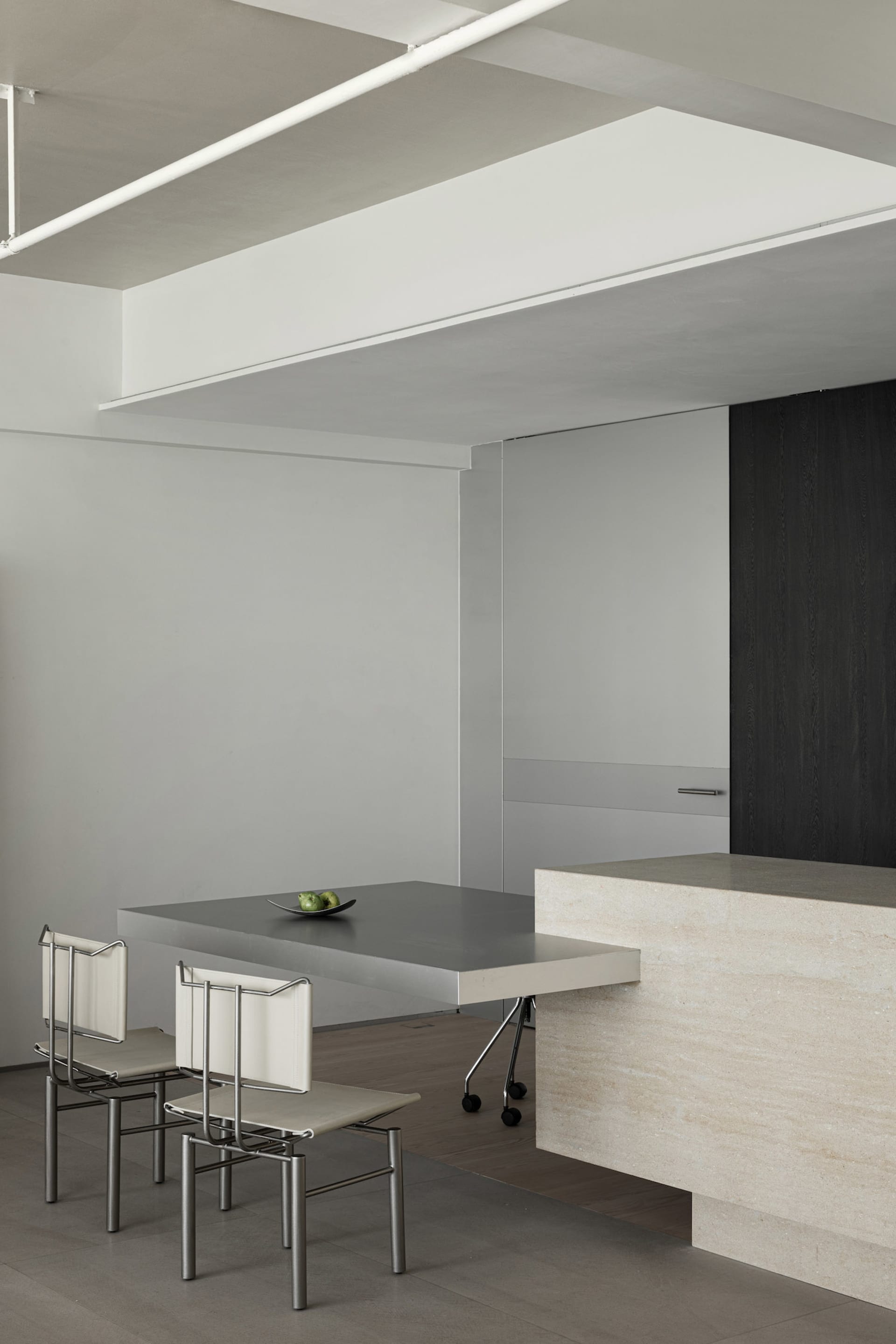 A modern interior design featuring a metallic table with minimalist chairs.
