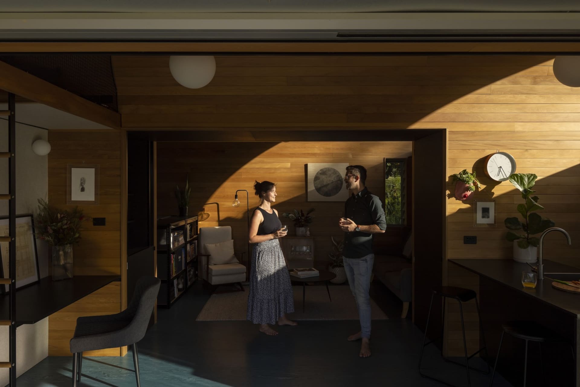 A modern interior design featuring wooden walls, glass elements, and steel accents.
