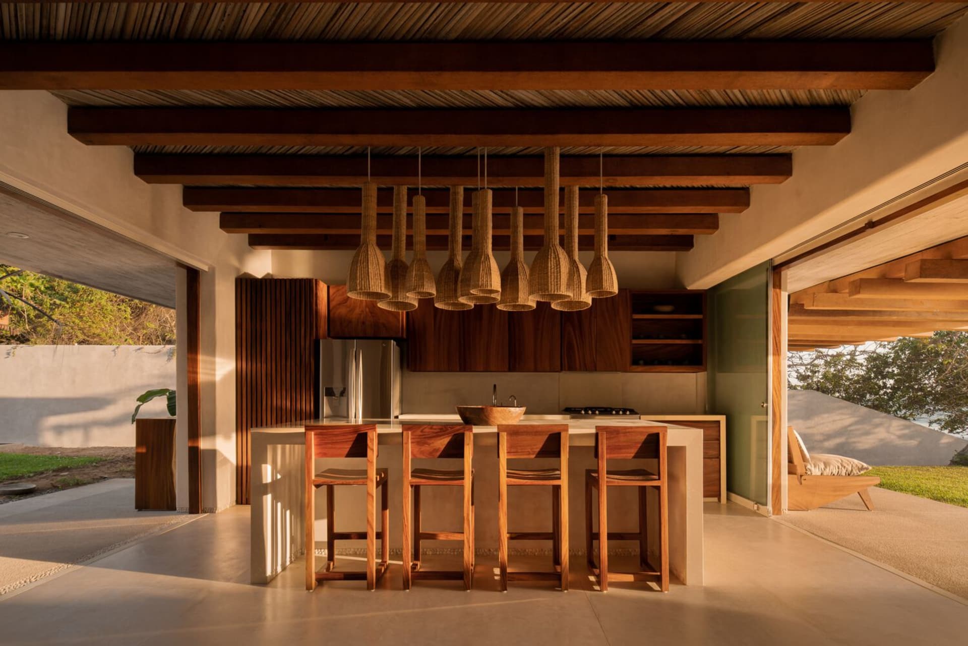 Modern residential kitchen featuring wood finishes and a bar counter with stools.