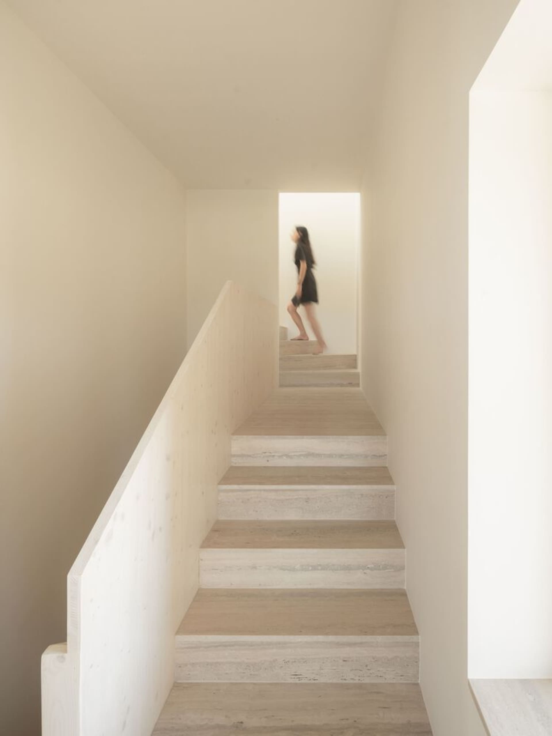 A modern staircase with marble steps and railings in a minimalist setting.