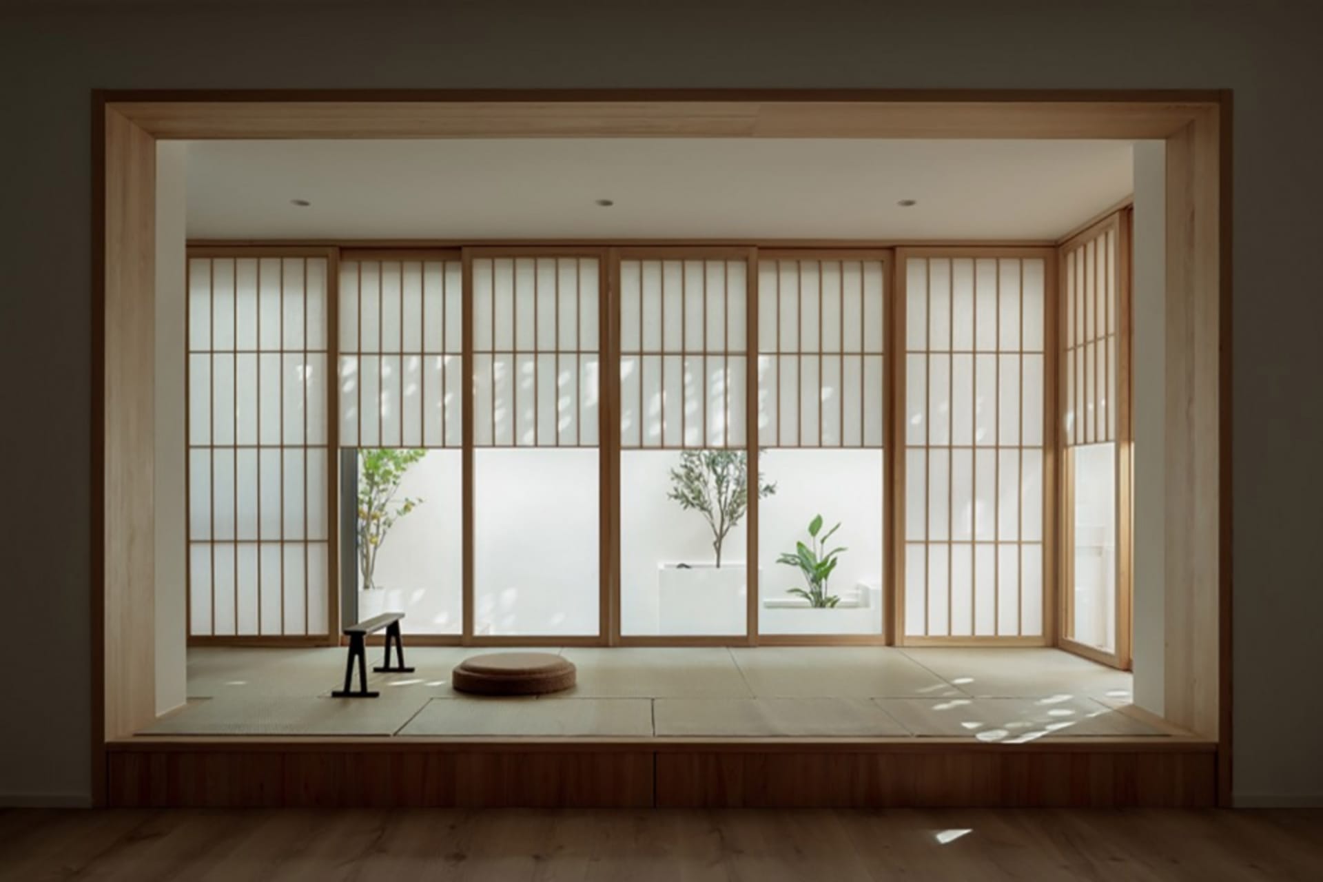 A modern interior with sliding wooden doors, plants, and a tatami mat.
