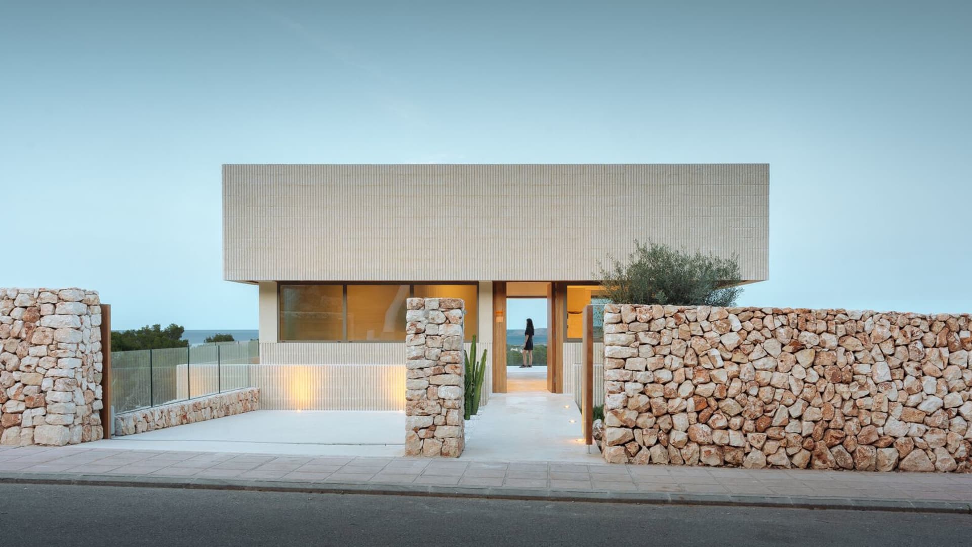 A modern residential home featuring a concrete and stone exterior.