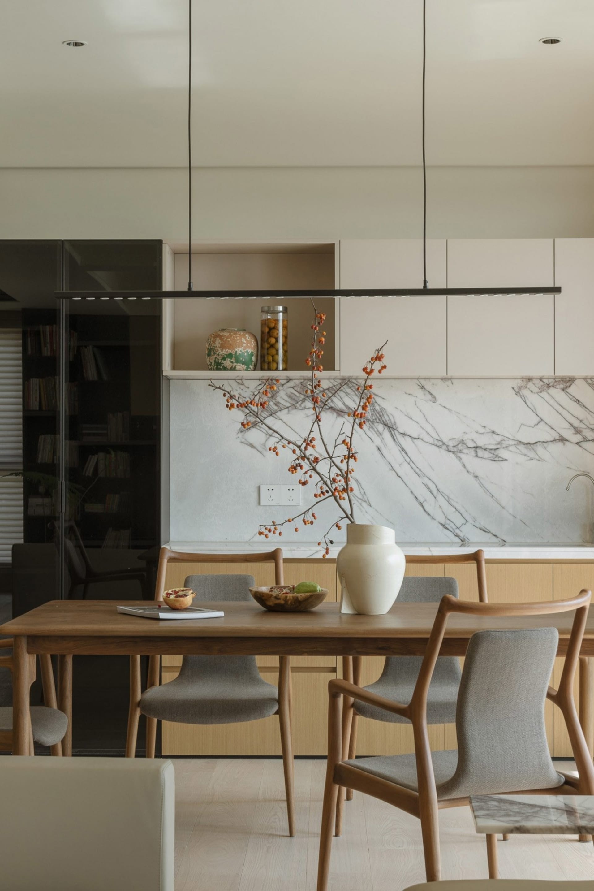 A modern residential interior featuring concrete flooring, wooden furniture, and marble accents.