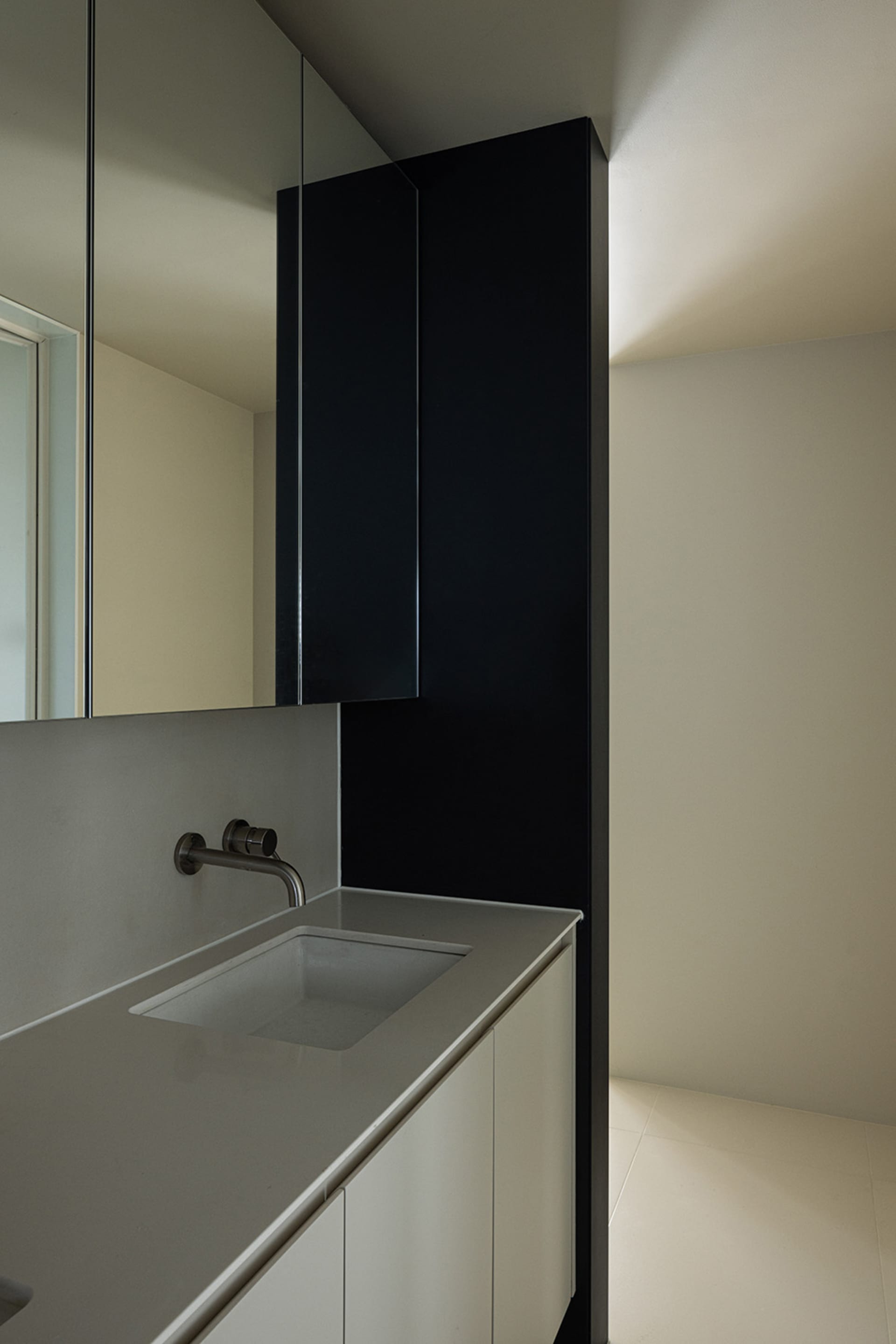 Modern bathroom with a minimalist design featuring ceramic tiles and black accents.