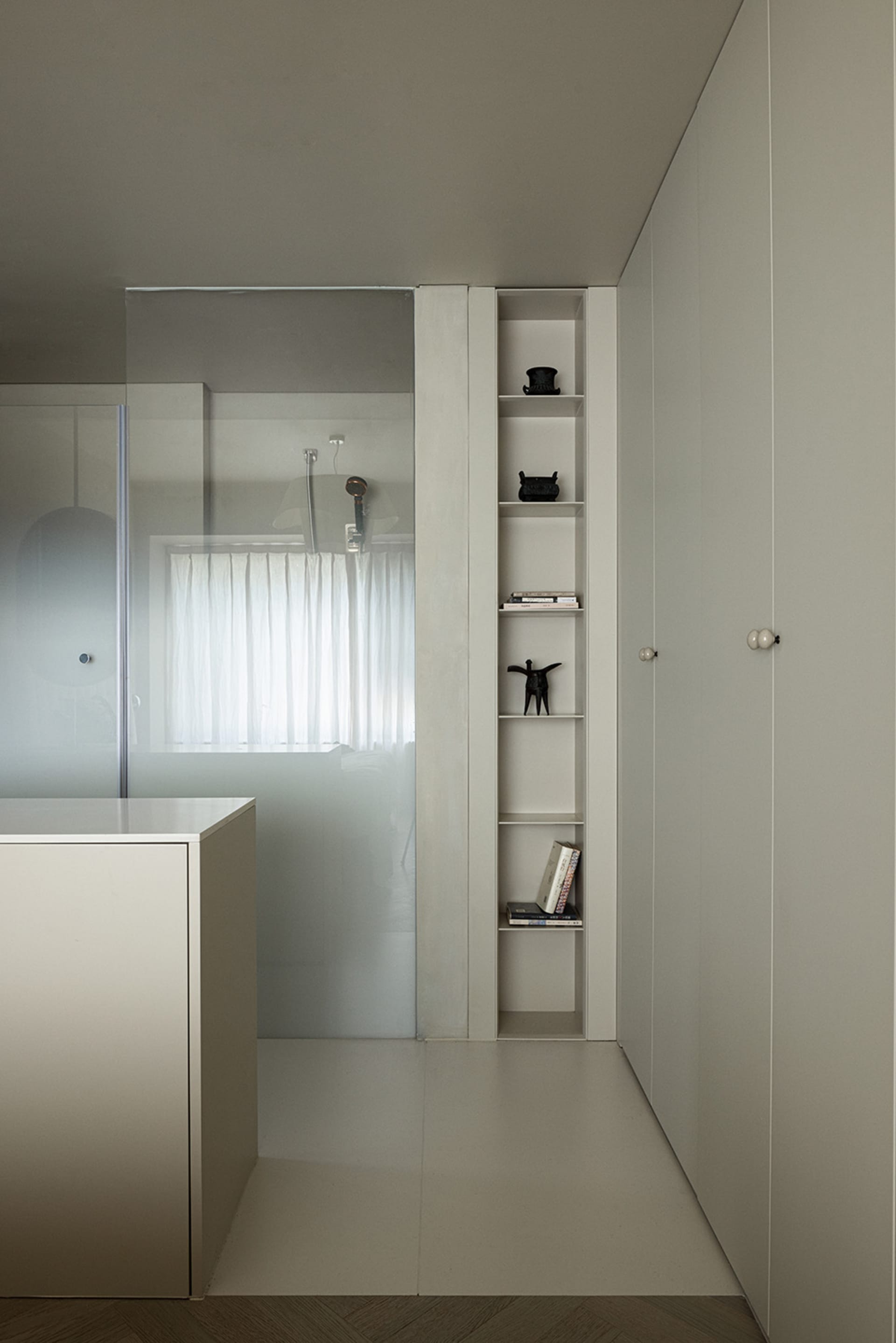 A minimalist modern bathroom with concrete shelving and a frosted glass wall.